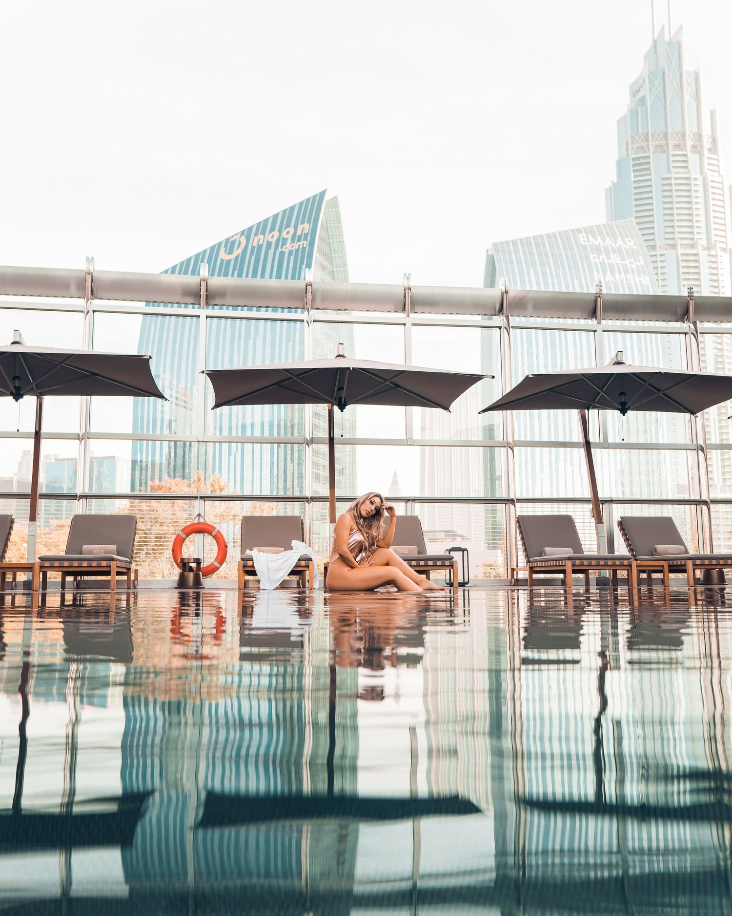 People relaxing in an infinity pool overlooking a city skyline at Marina Bay Sands hotel in Singapore.