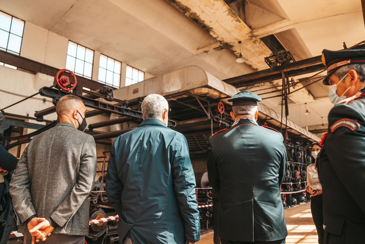 Business professionals gather in a modern industrial office space for a collaborative meeting or presentation.