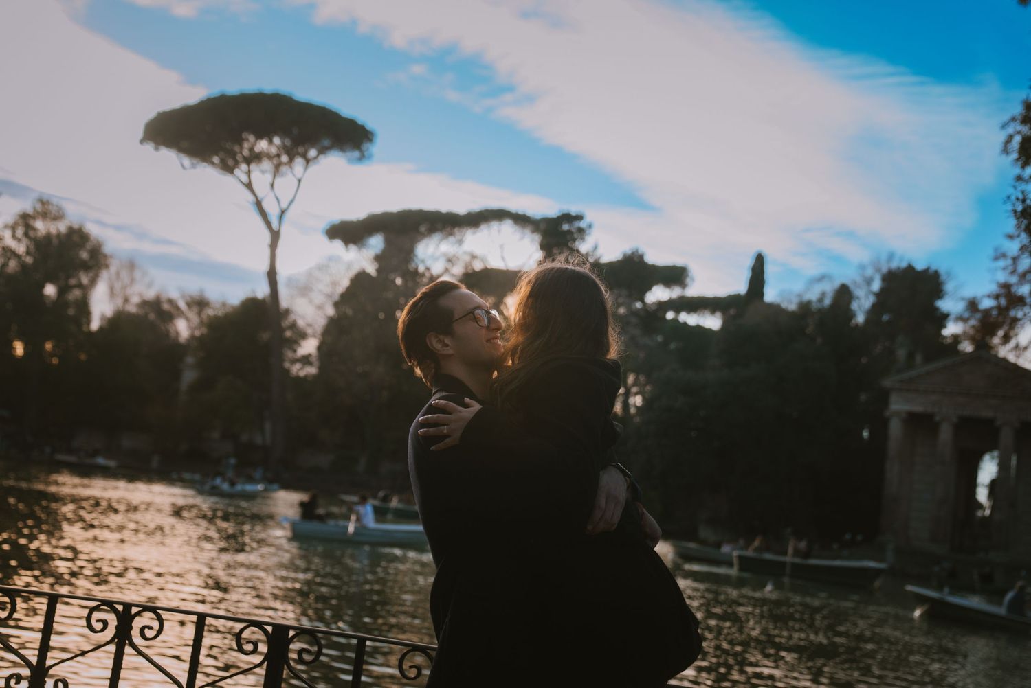 Scenic sunset view of Rome with silhouetted trees and architecture.