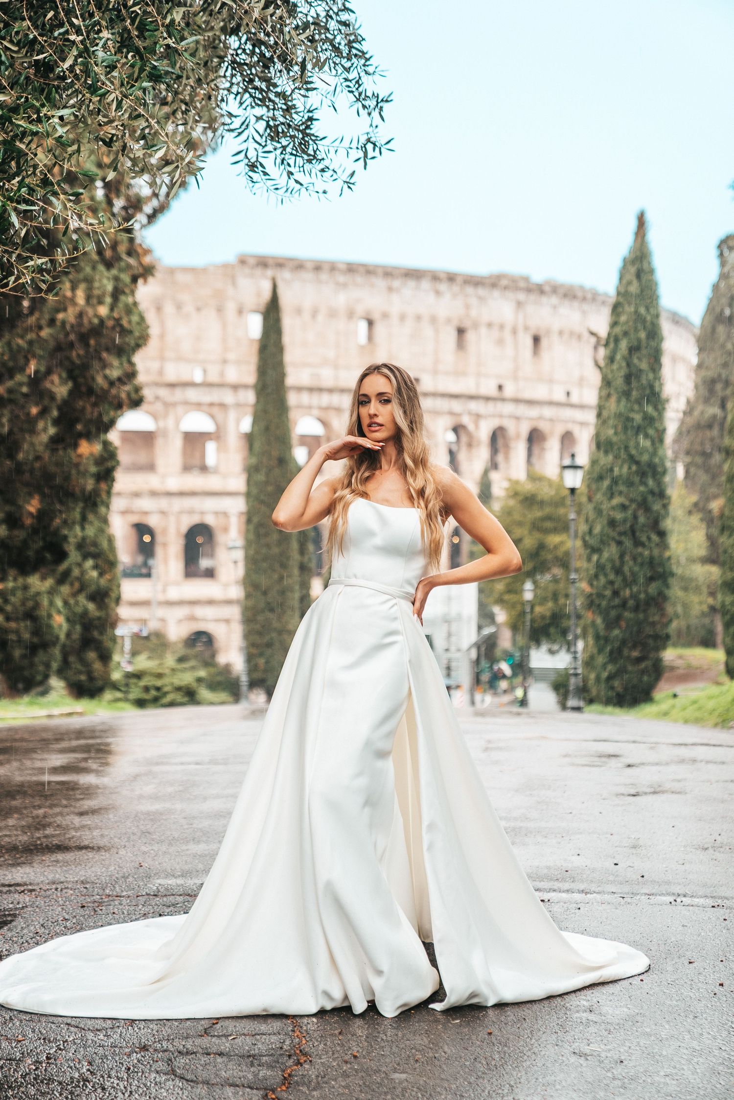 Stunning bridal portrait with the Colosseum and cypress trees creating a romantic Italian backdrop.