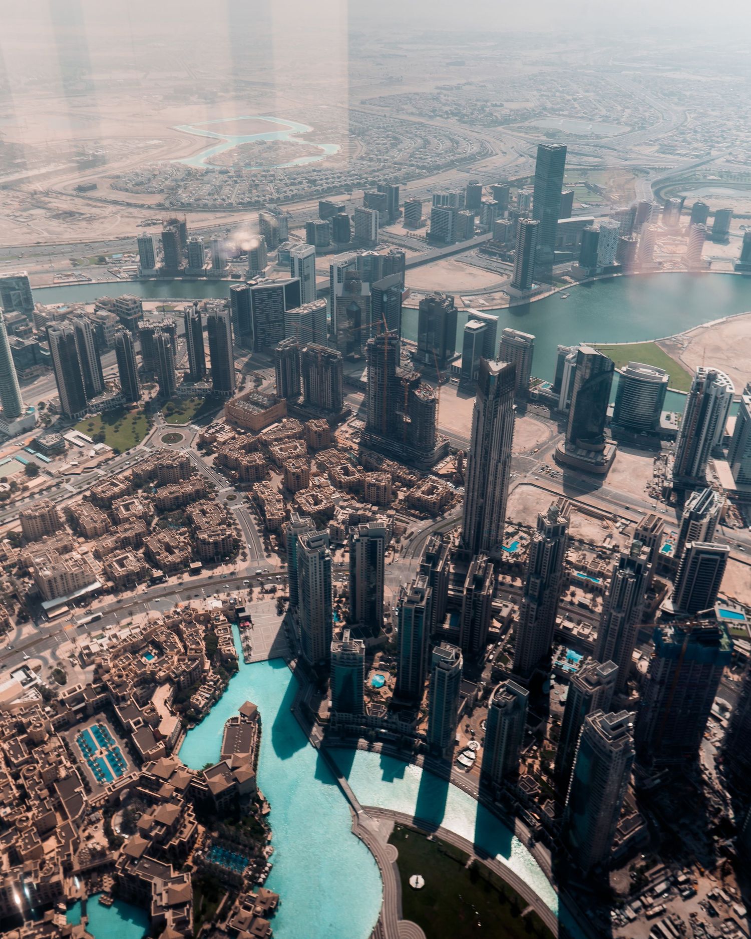 Aerial panoramic view of Dubai Marina and surrounding skyscrapers with turquoise waters of the Persian Gulf.