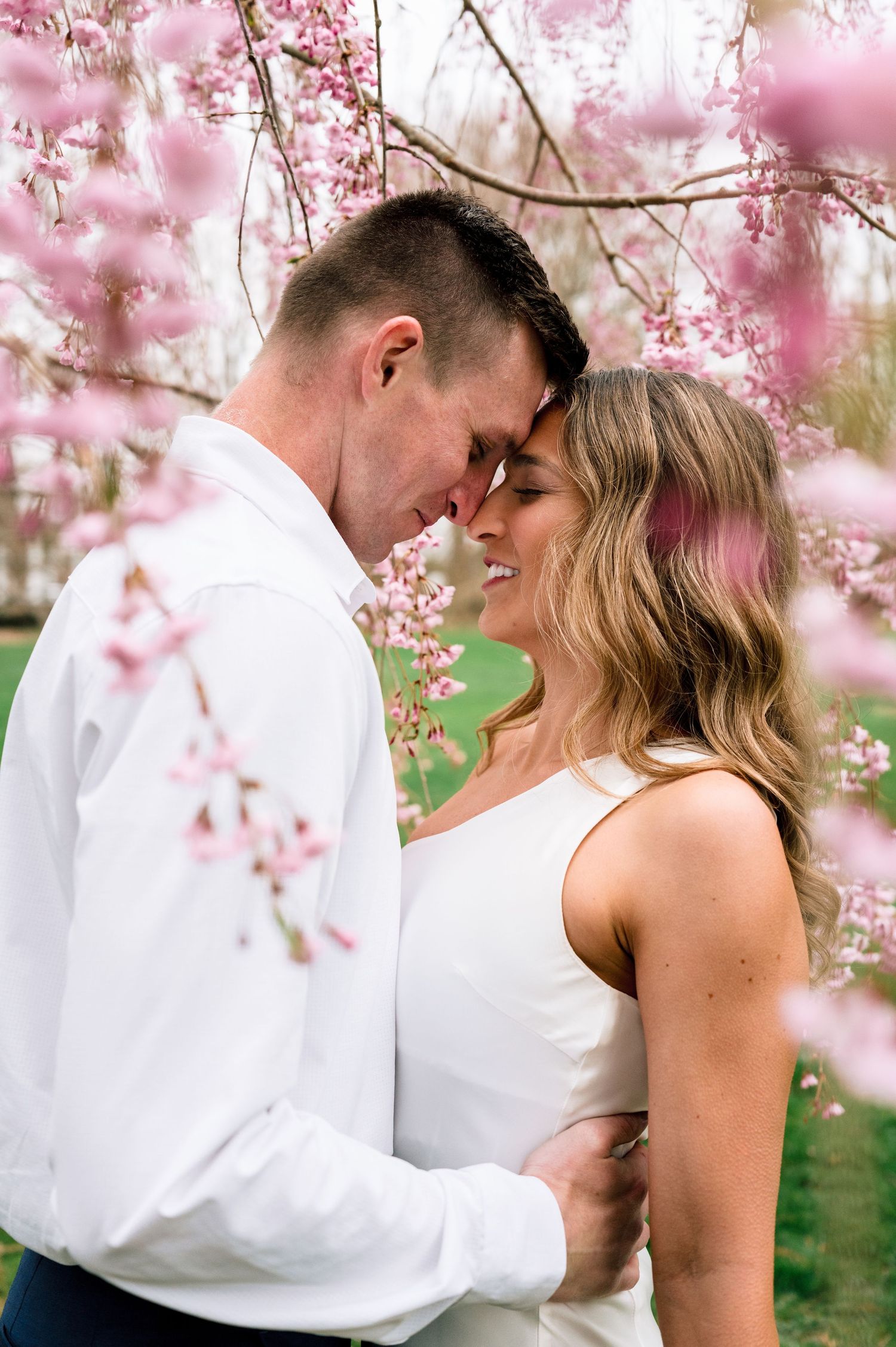 Romantic engagement portrait beneath blooming spring flowers at Blithewold Manor, Gardens & Arboretum.