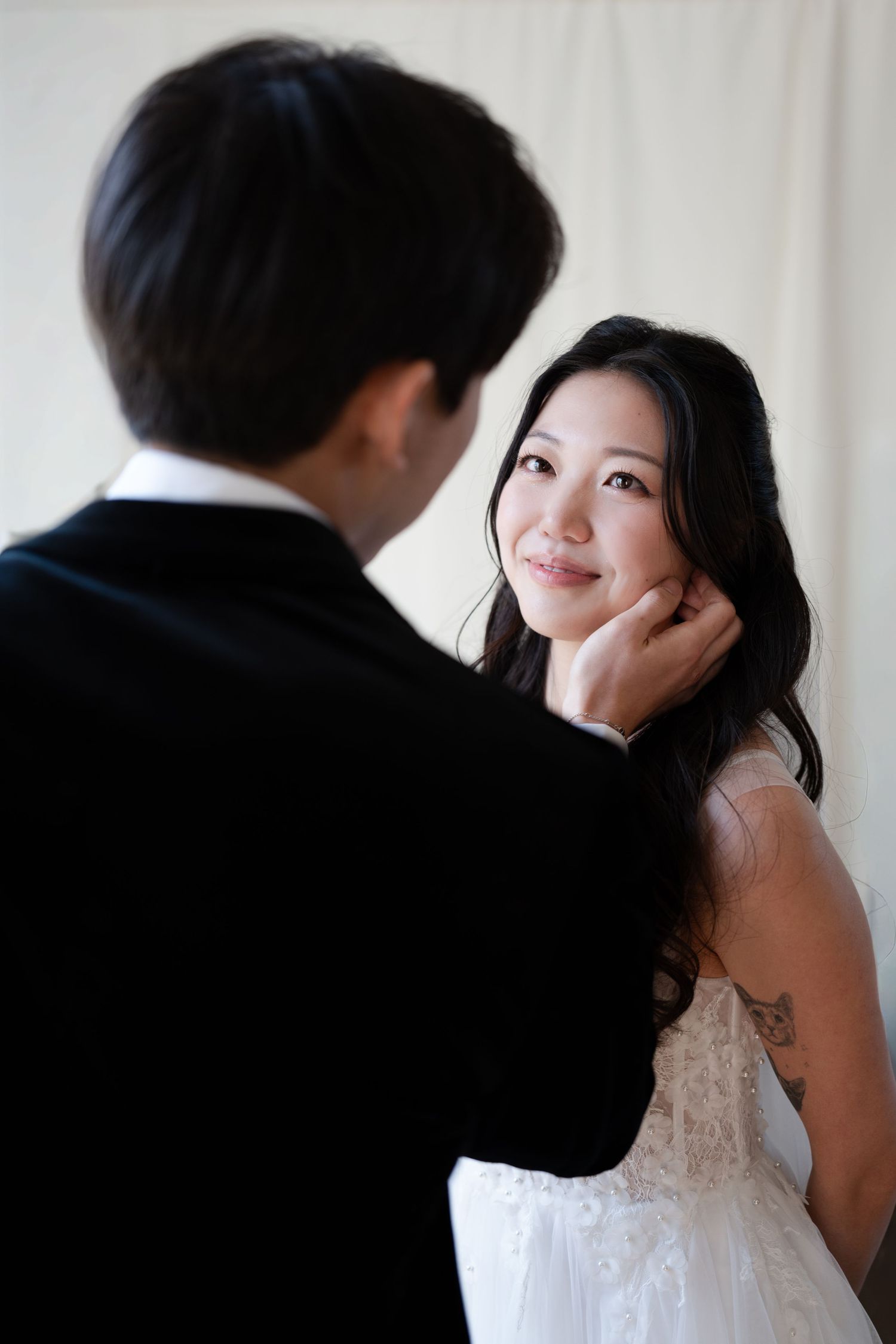 Groom gently touching the bride's face during a romantic wedding portrait.