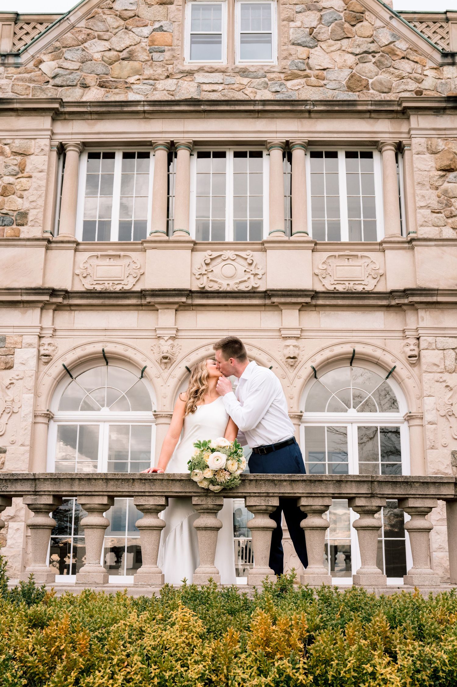 Couple embracing in front of Blithewold Manor during an editorial engagement session in Bristol, Rhode Island.