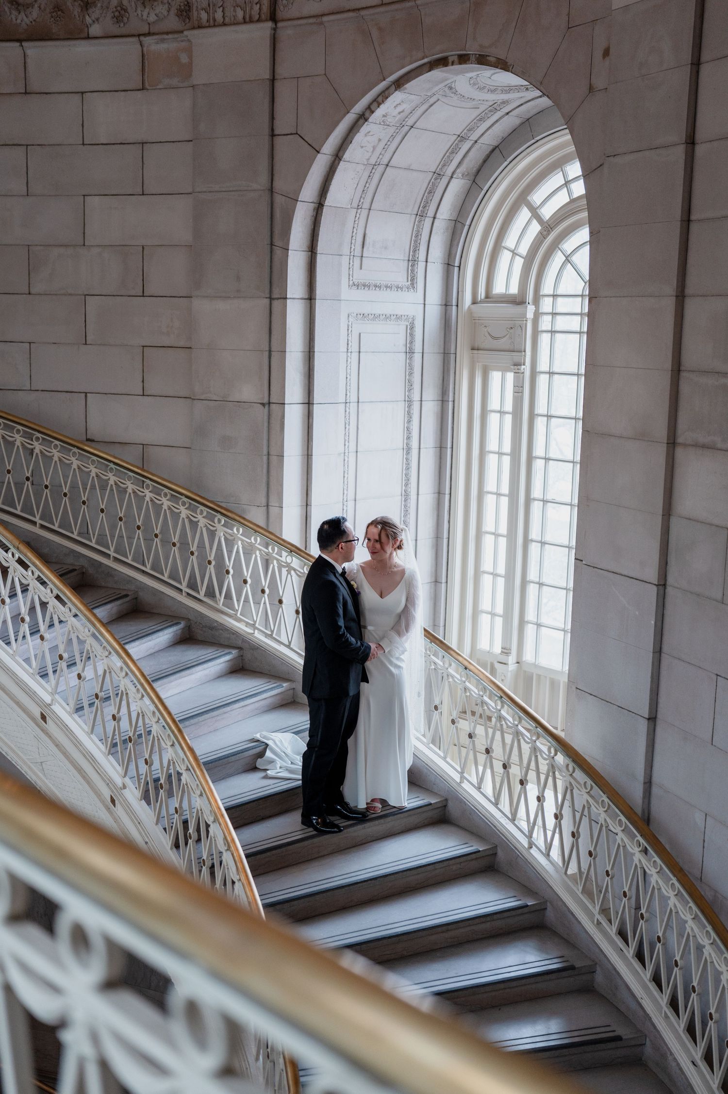 Newlyweds embracing on the historic spiral staircase at Hartford City Hall during an intimate Connecticut elopement.