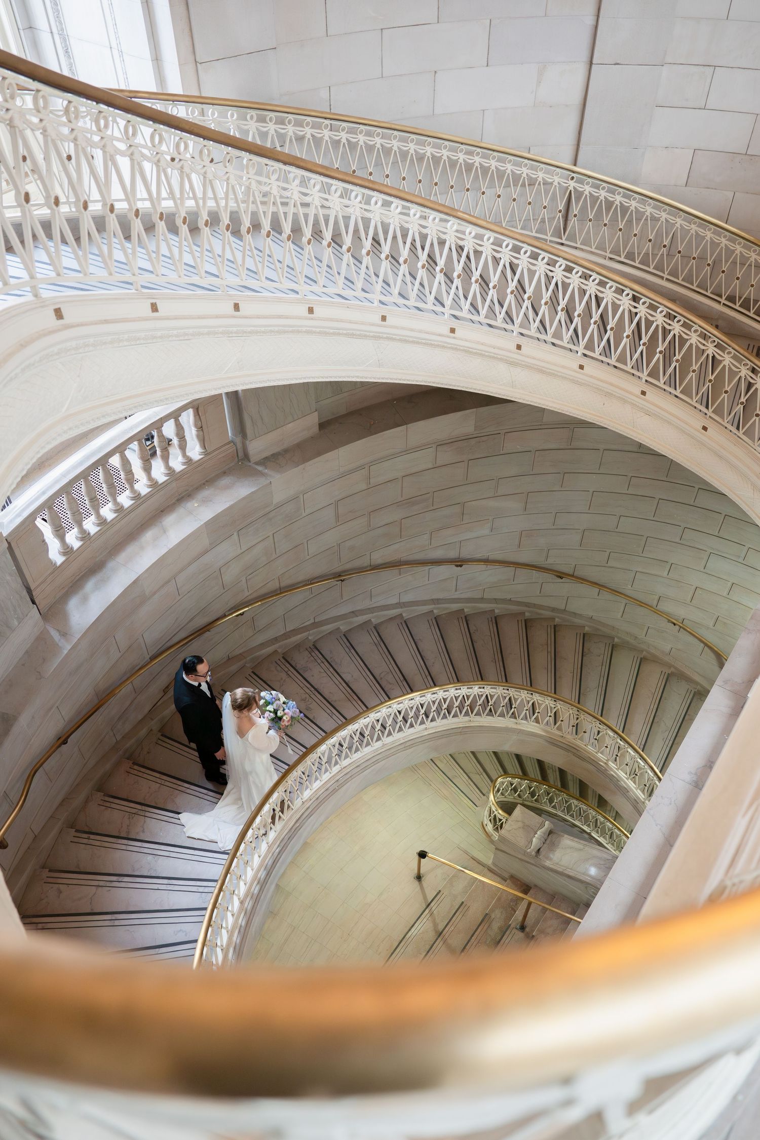 Newlyweds embracing on the historic spiral staircase at Hartford City Hall during an intimate Connecticut elopement.