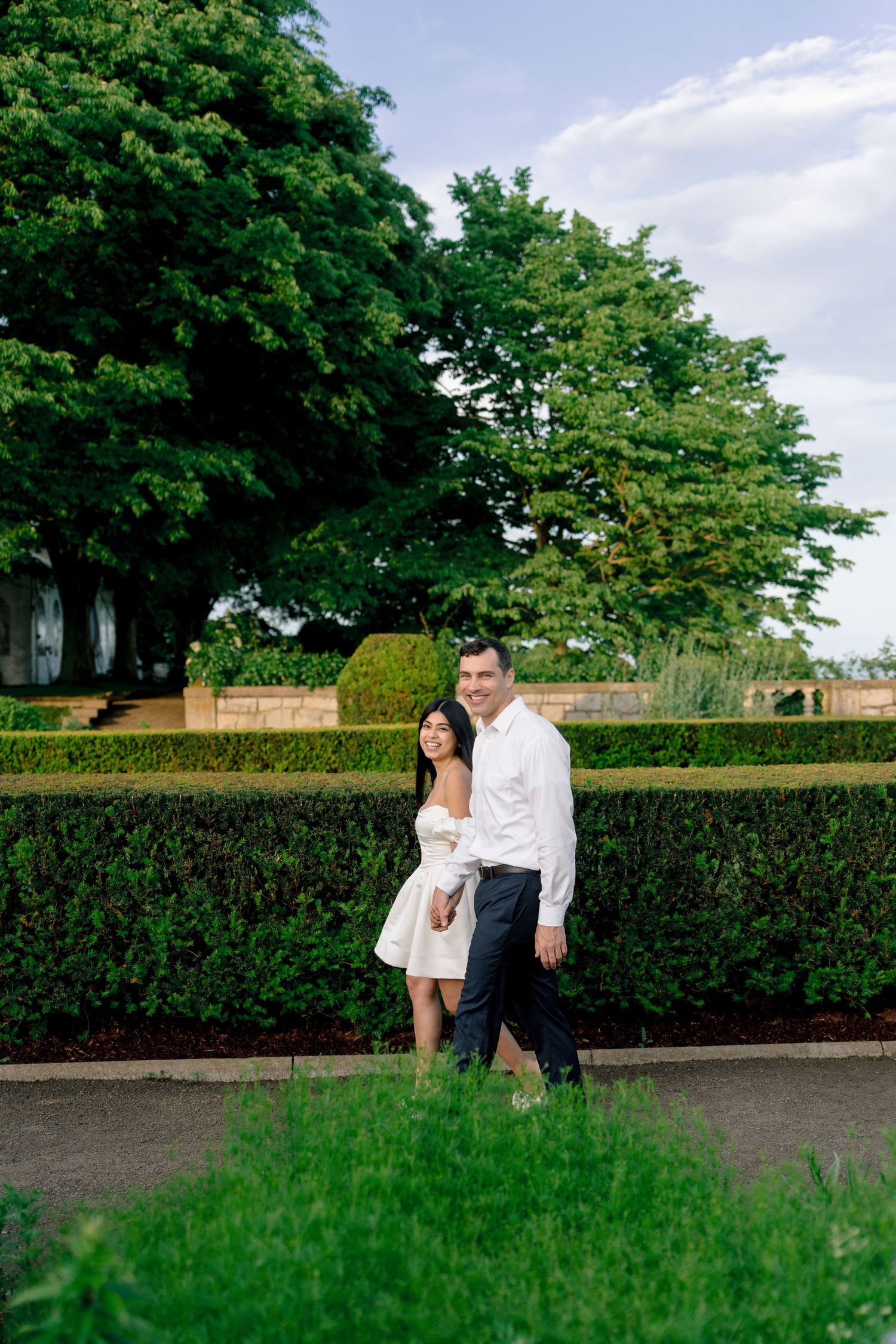 Couple walking through the formal gardens during an engagement session at Harkness Memorial State Park in Waterford, Connecticut.