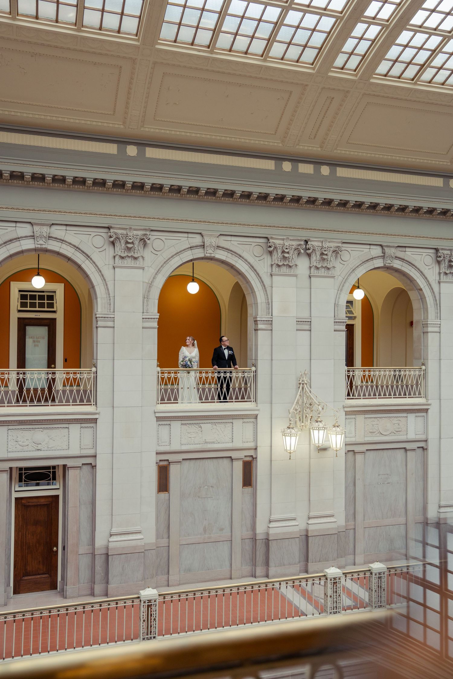 Bride and groom overlooking the historic architecture at Hartford City Hall following their Connecticut elopement ceremony.