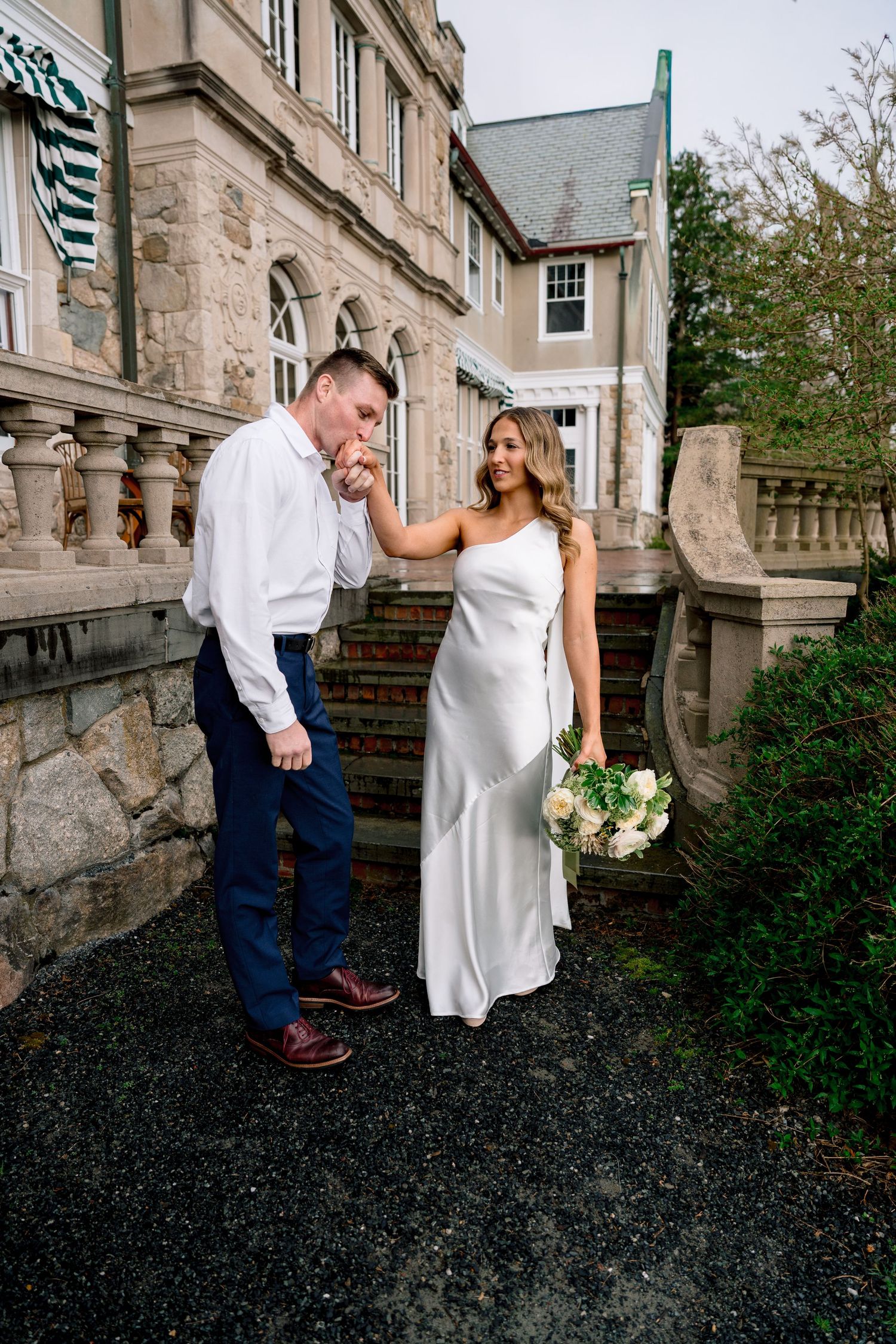 Couple walking down the historic stone steps at Blithewold Manor, Gardens & Arboretum during an engagement session in Bristol, Rhode Island.