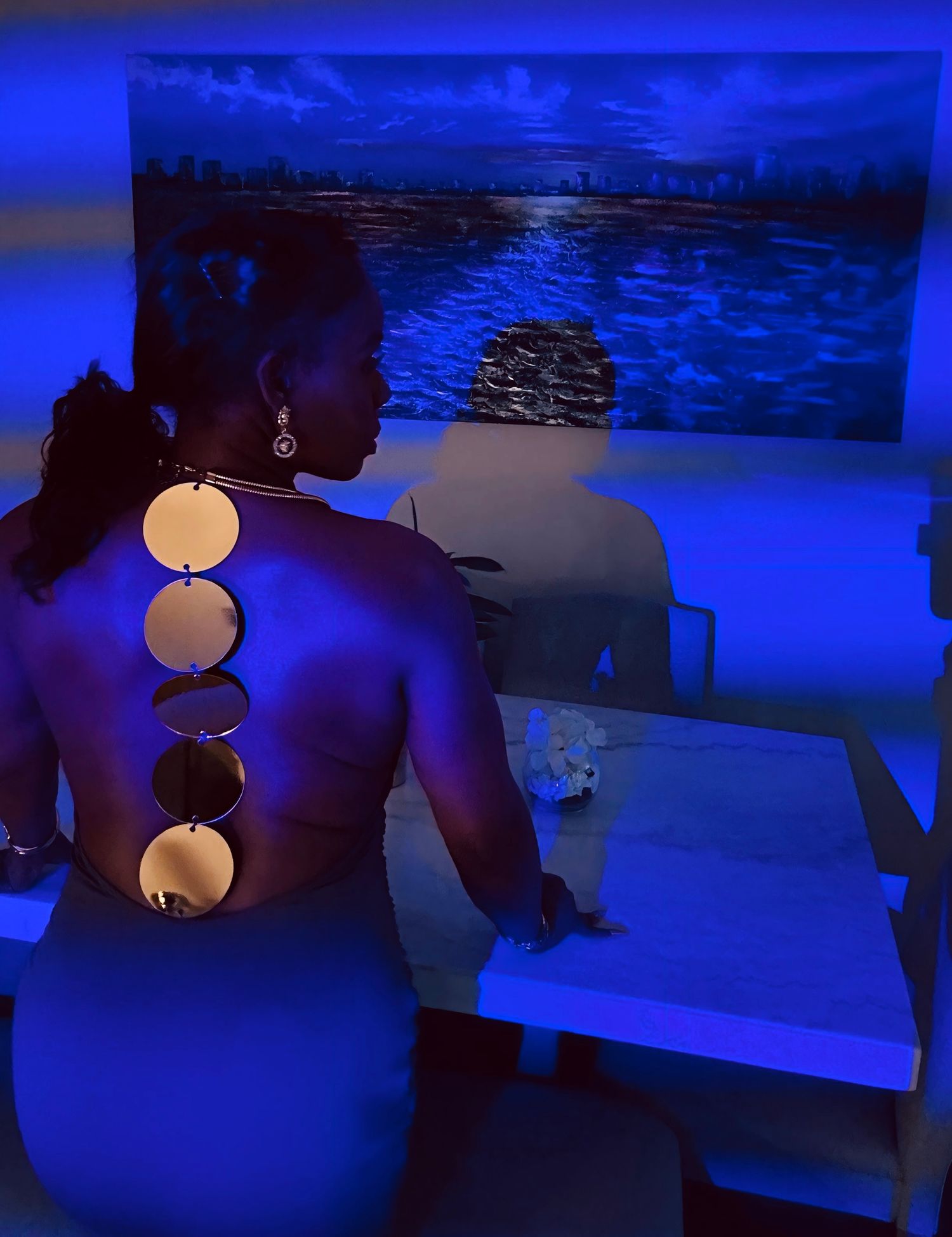 A series of dark blue-lit photos showing illuminated pendant lamps casting a moody glow in a dimly lit space.