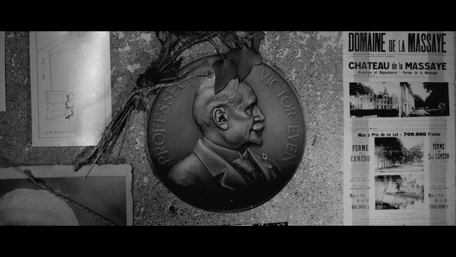 Black and white close-up of a bronze medallion portrait beside vintage French newspaper clippings.