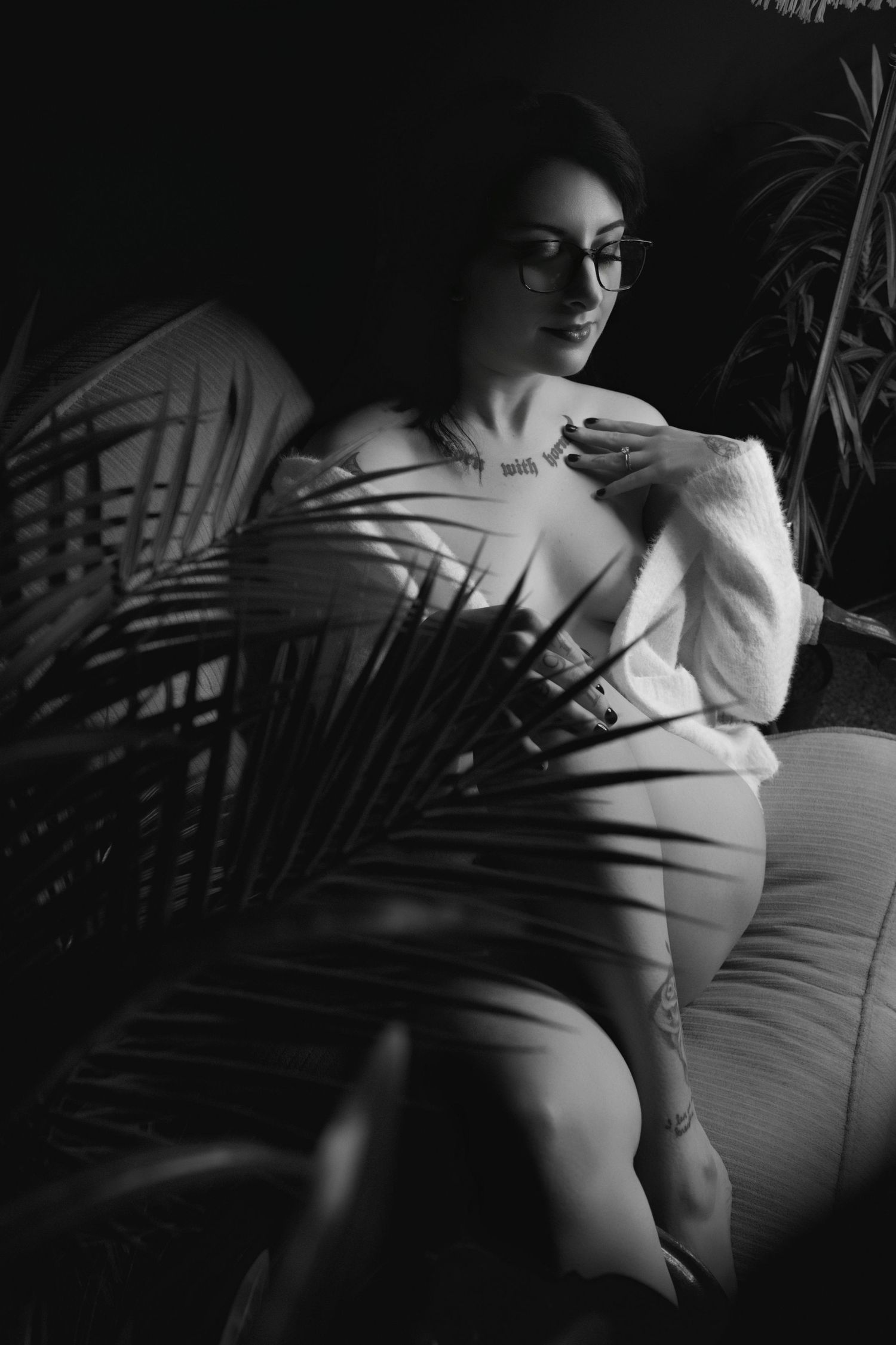 Artistic black and white boudoir portrait featuring dramatic studio lighting.