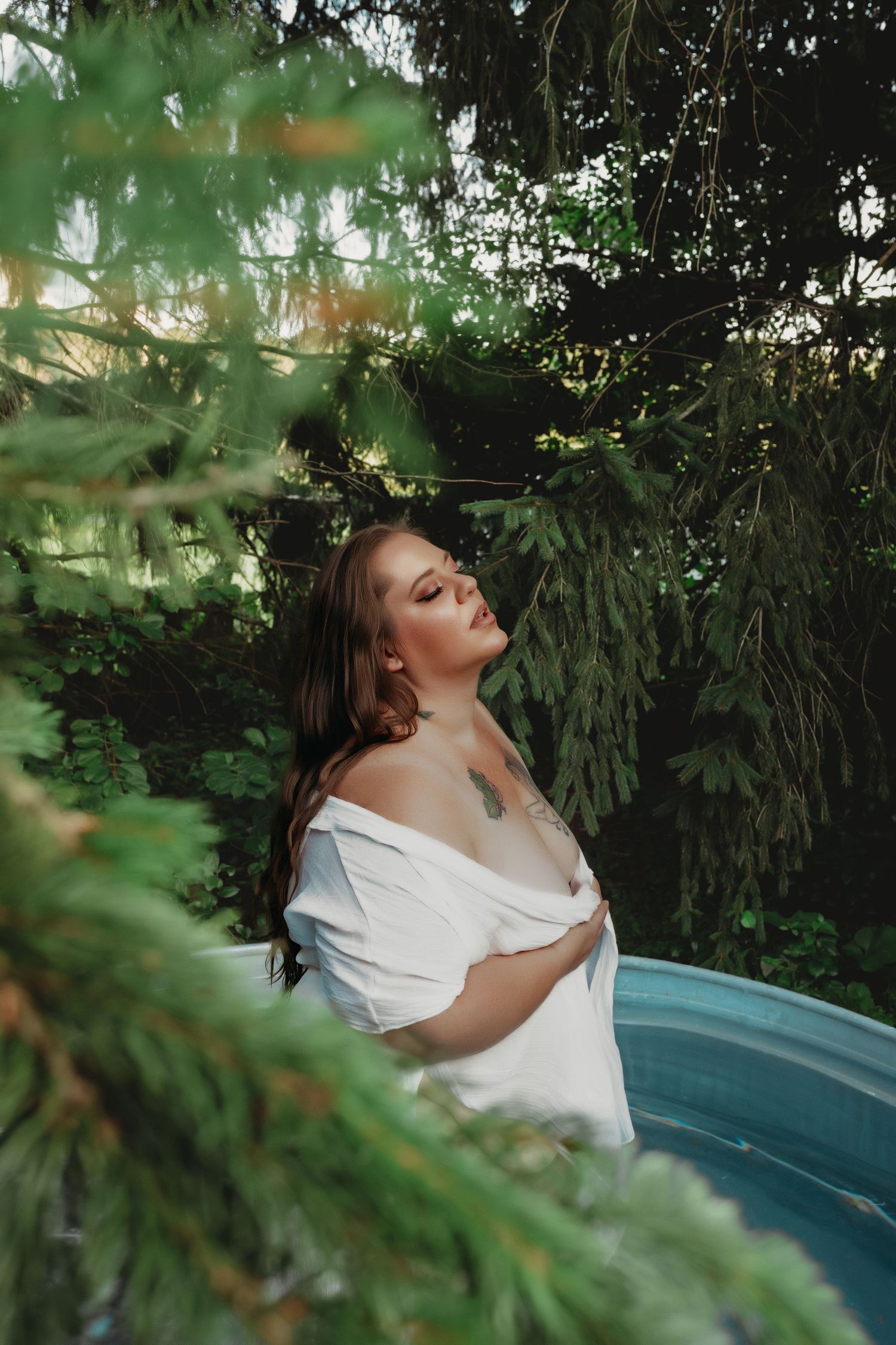 Pool image of a woman in white, surrounded by trees.