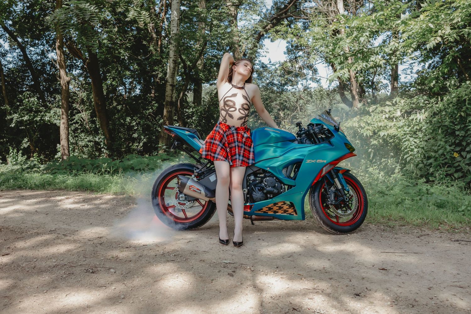 Boudoir portrait of a woman and her motorcycle outdoors.