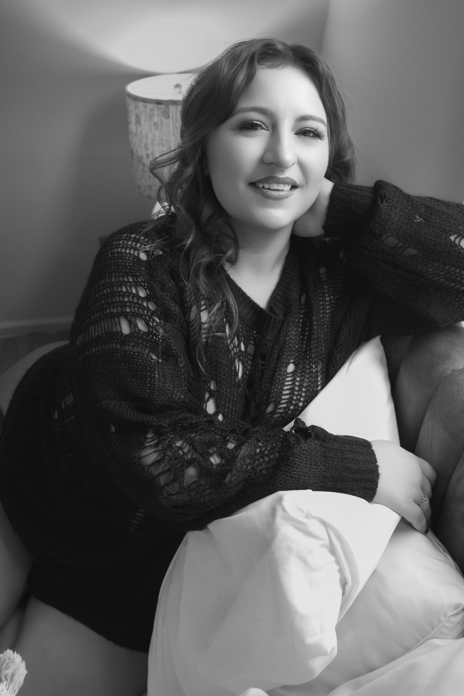 Relaxed black and white portrait of woman during a luxury boudoir photography session.