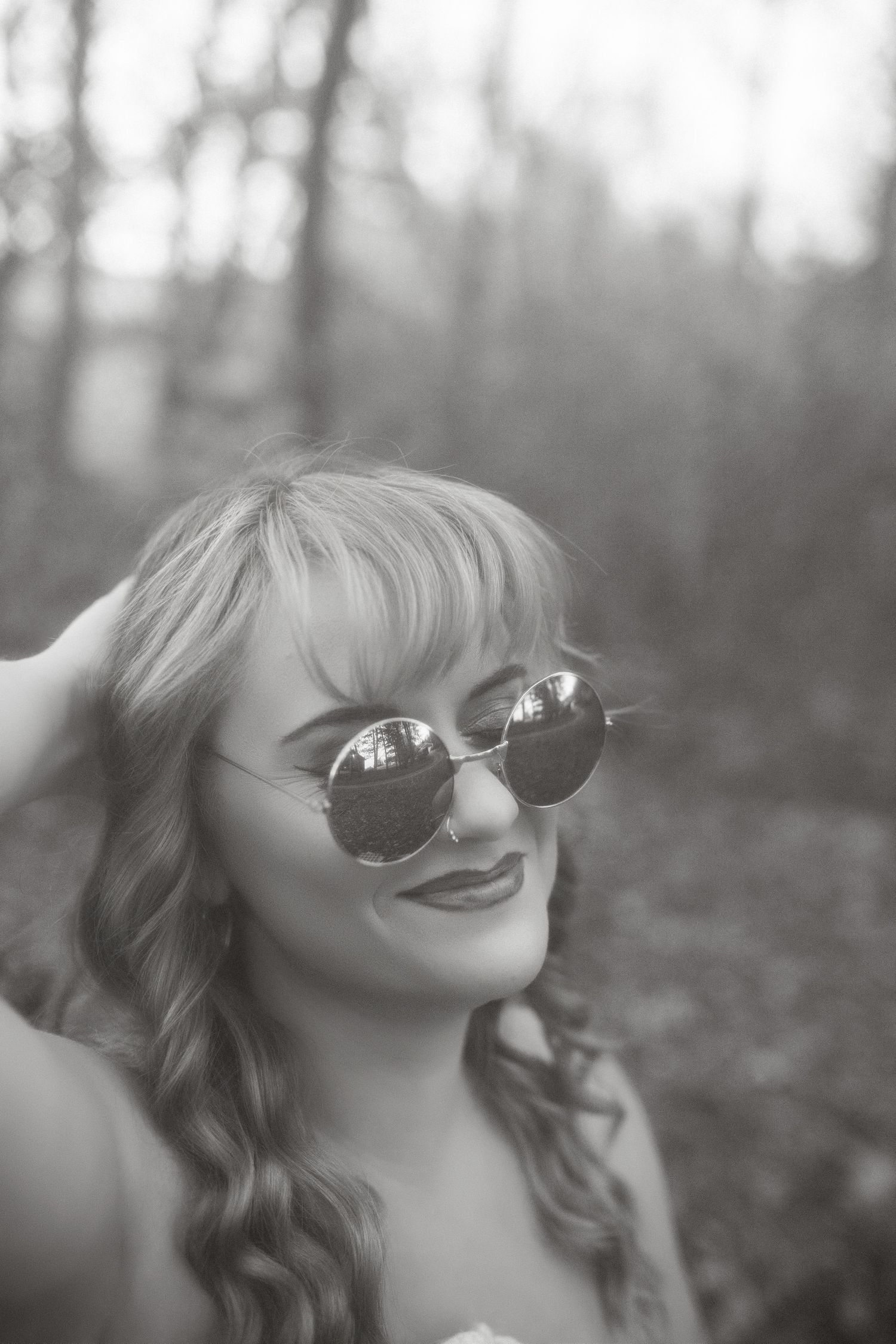 Black and white portrait of a smiling woman during a women's empowerment photography session.