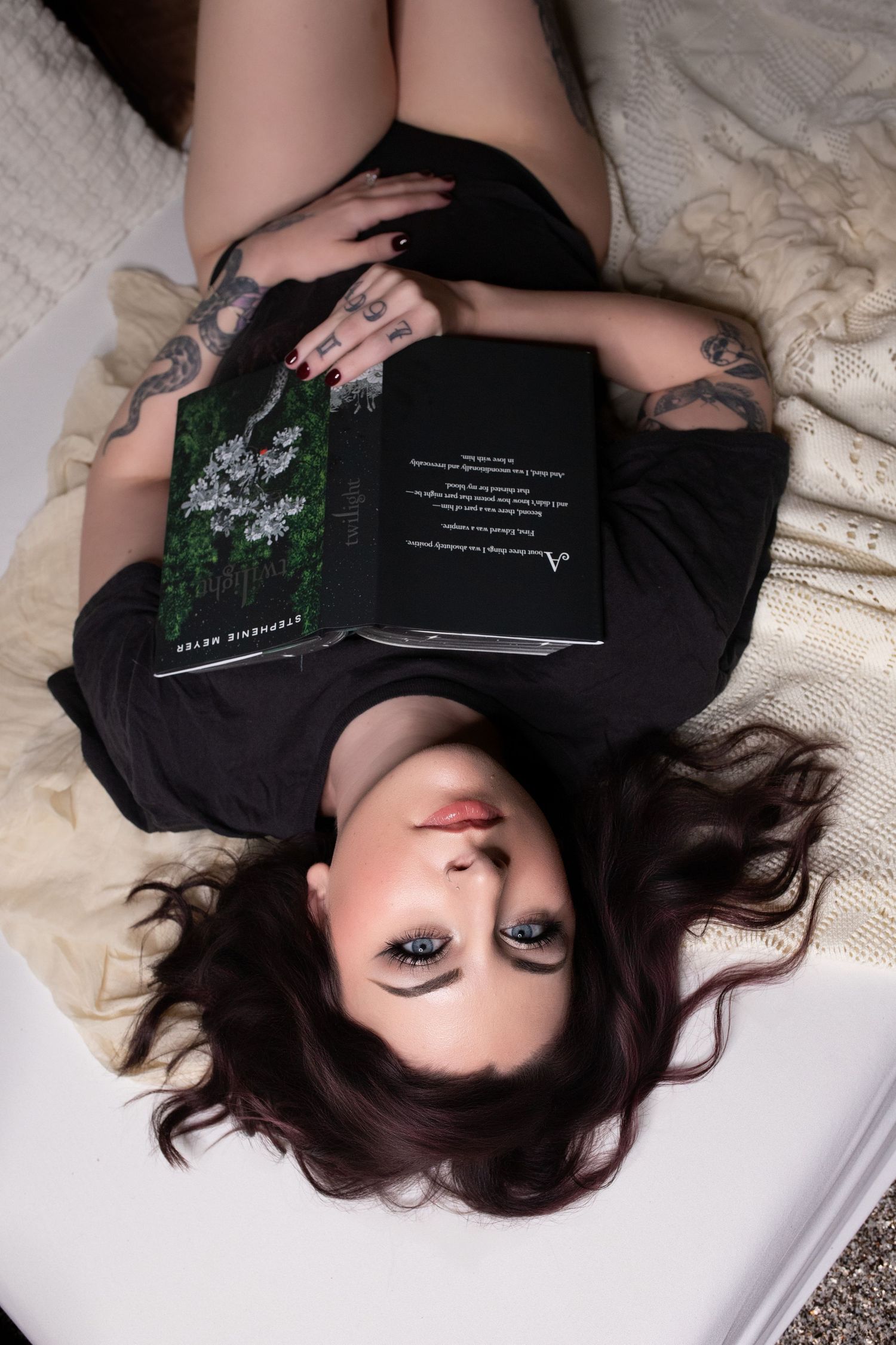 Woman relaxing on a bed during a luxury boudoir photography session.