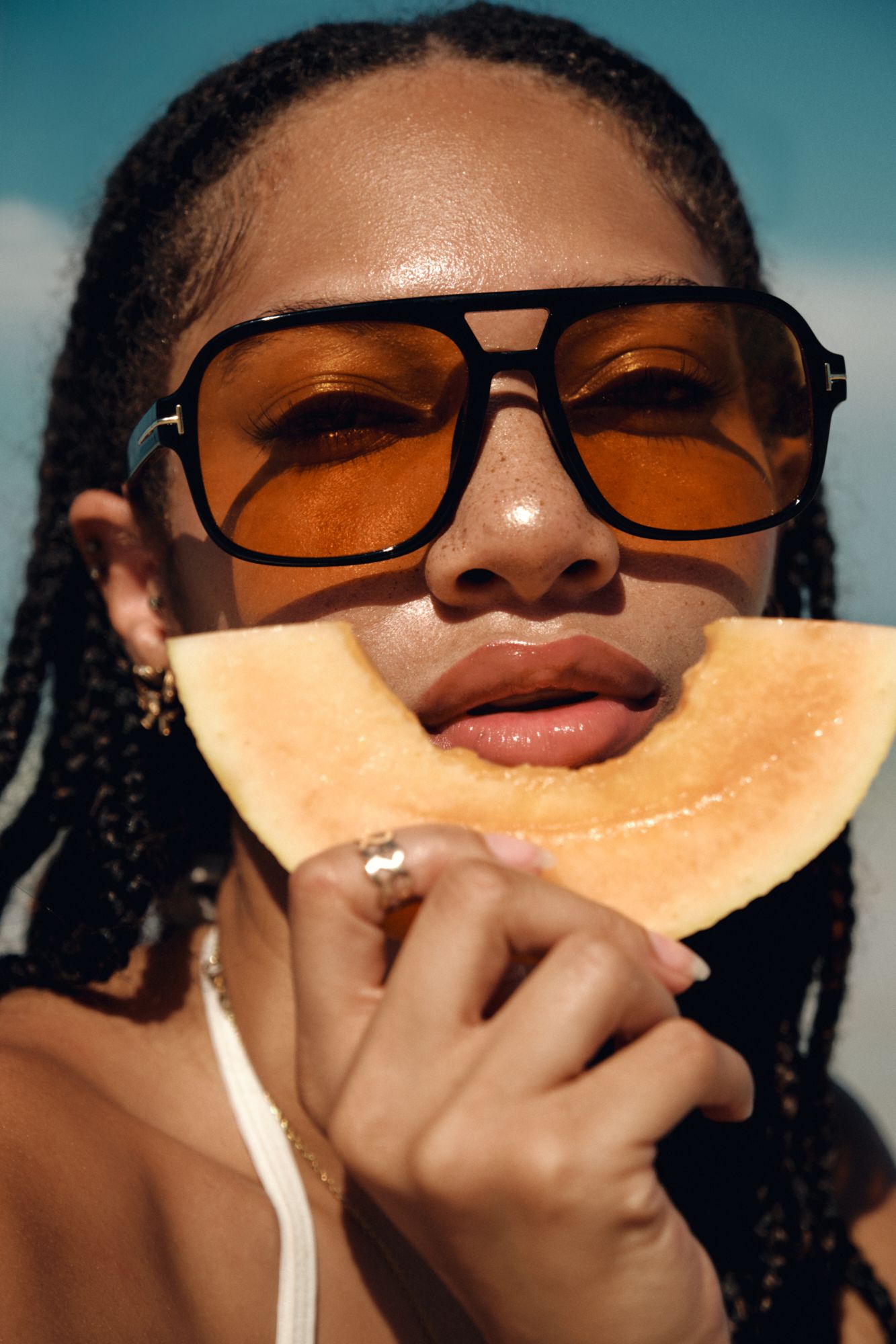 Close-up beach portrait series with amber sunglasses and dramatic lighting.