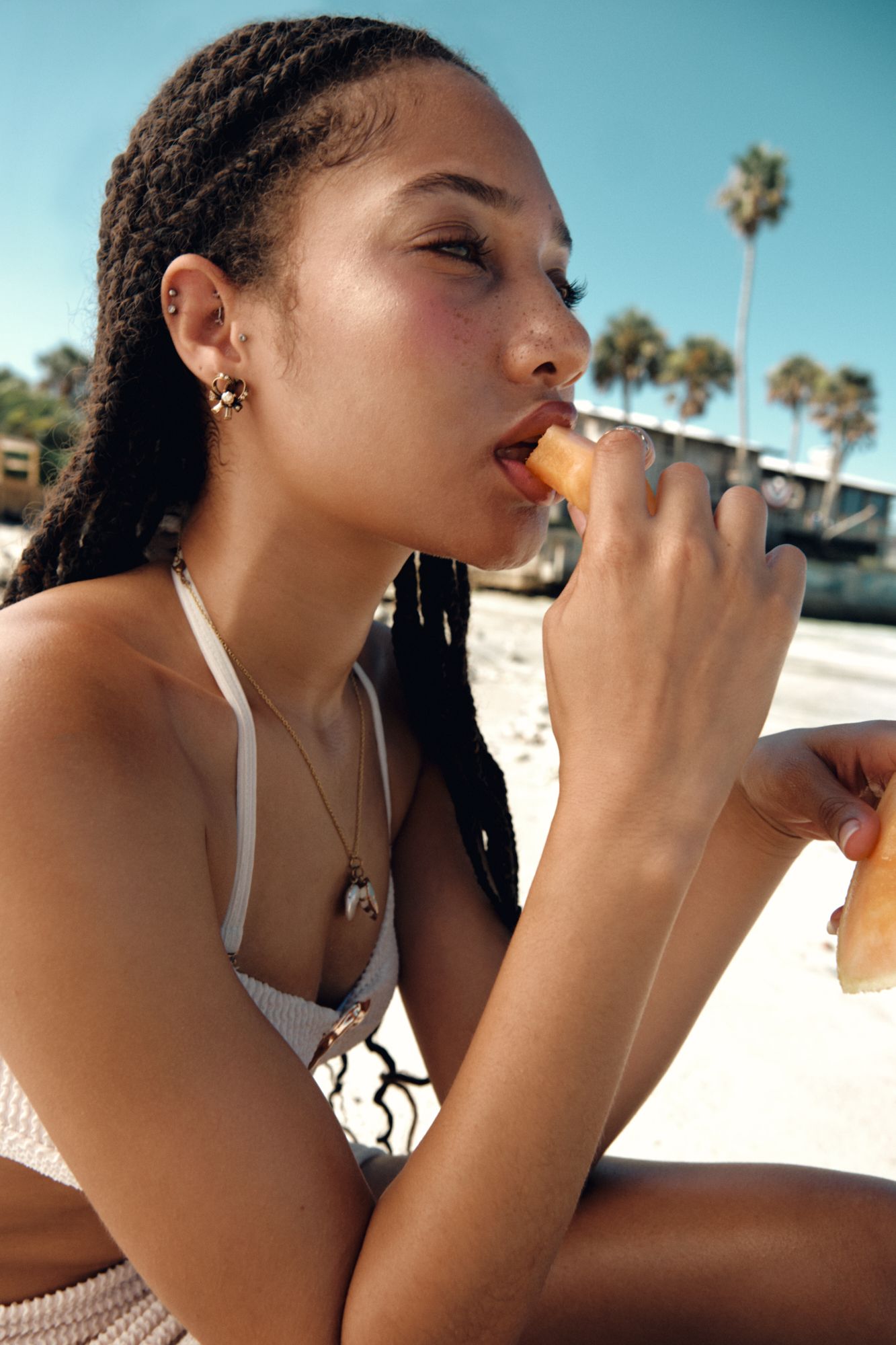 Side profile beach portrait sequence showing enjoyment of summer fruit.