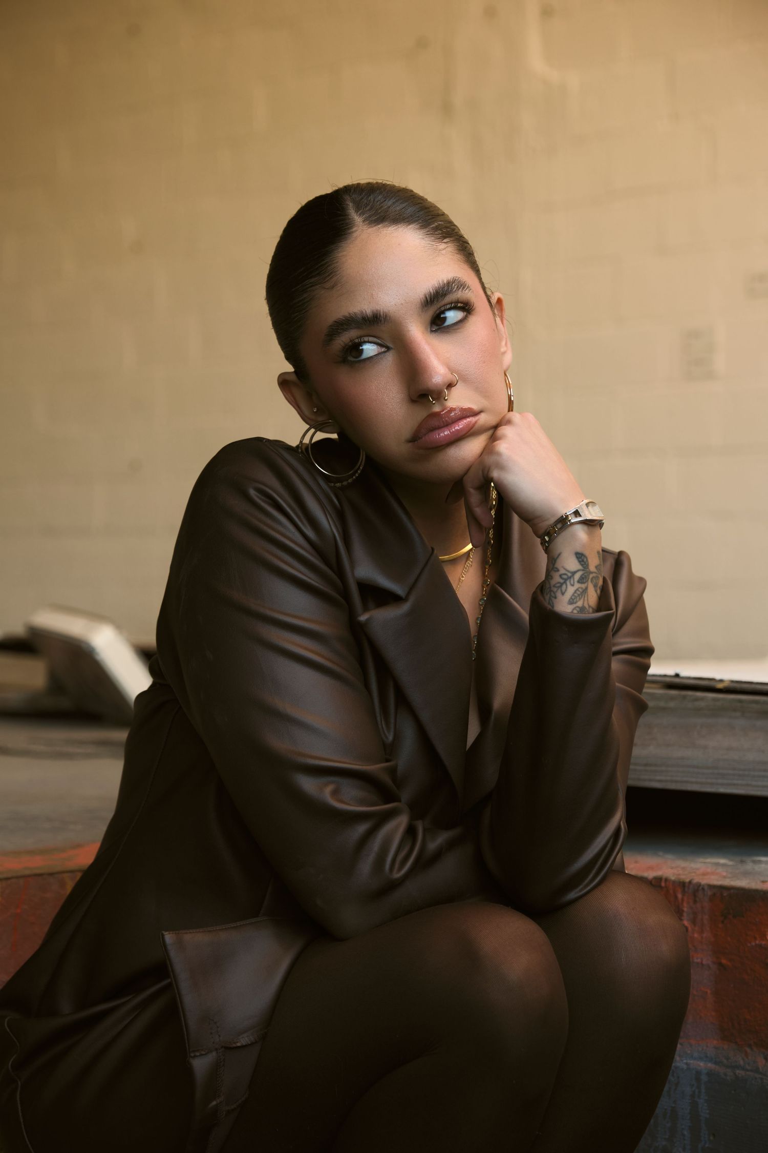 Artistic fashion portrait featuring leather jacket and dramatic makeup in sepia tones.