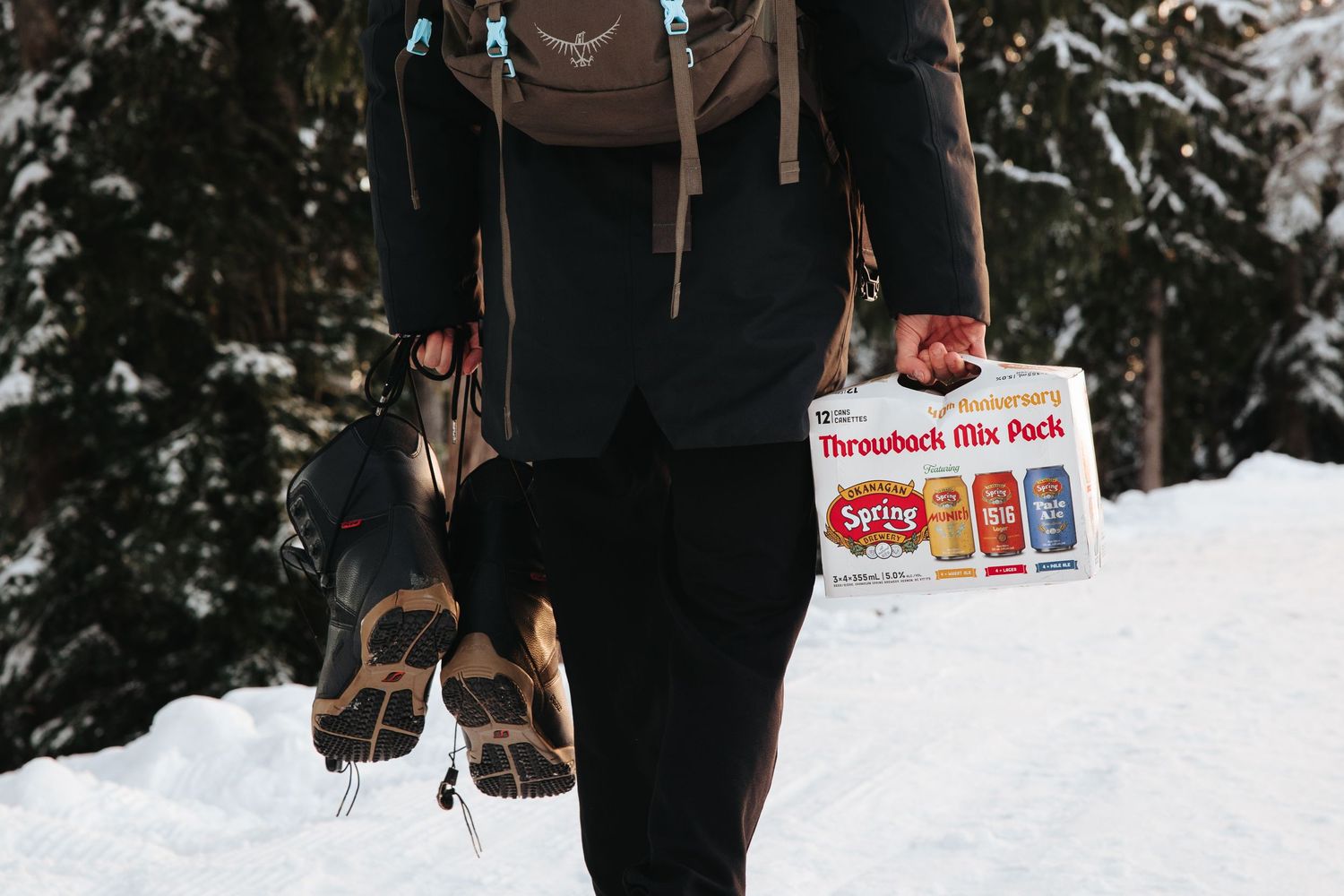 Winter scene showing person carrying beer cases through snowy landscape.