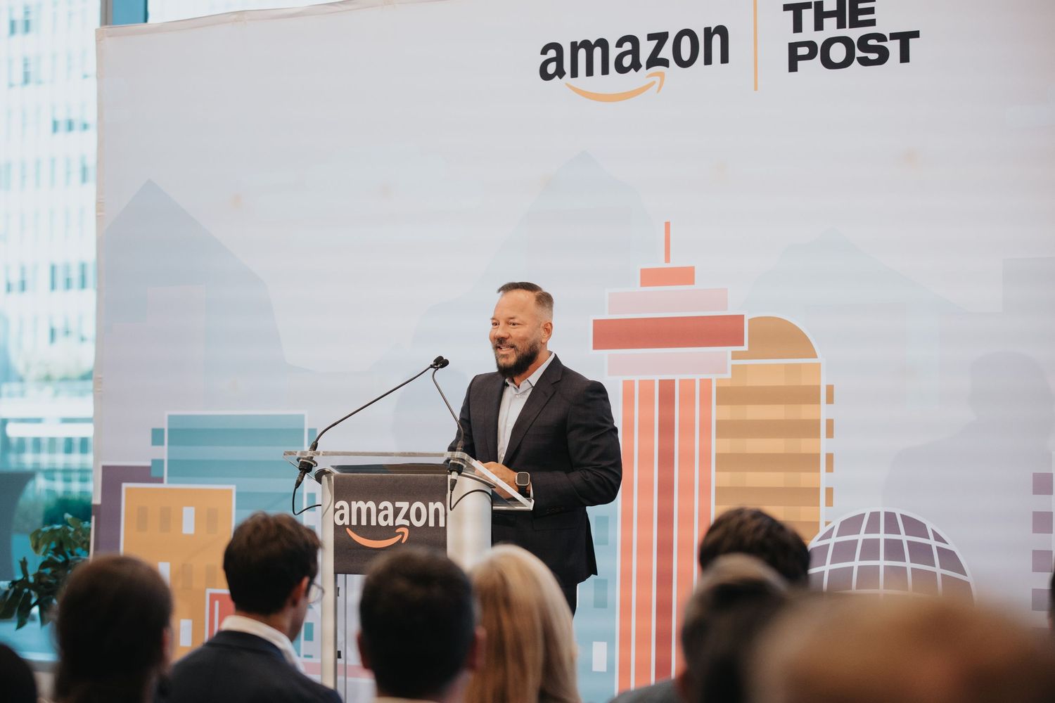 Conference stage with Amazon and The Post logos displayed on large screen.