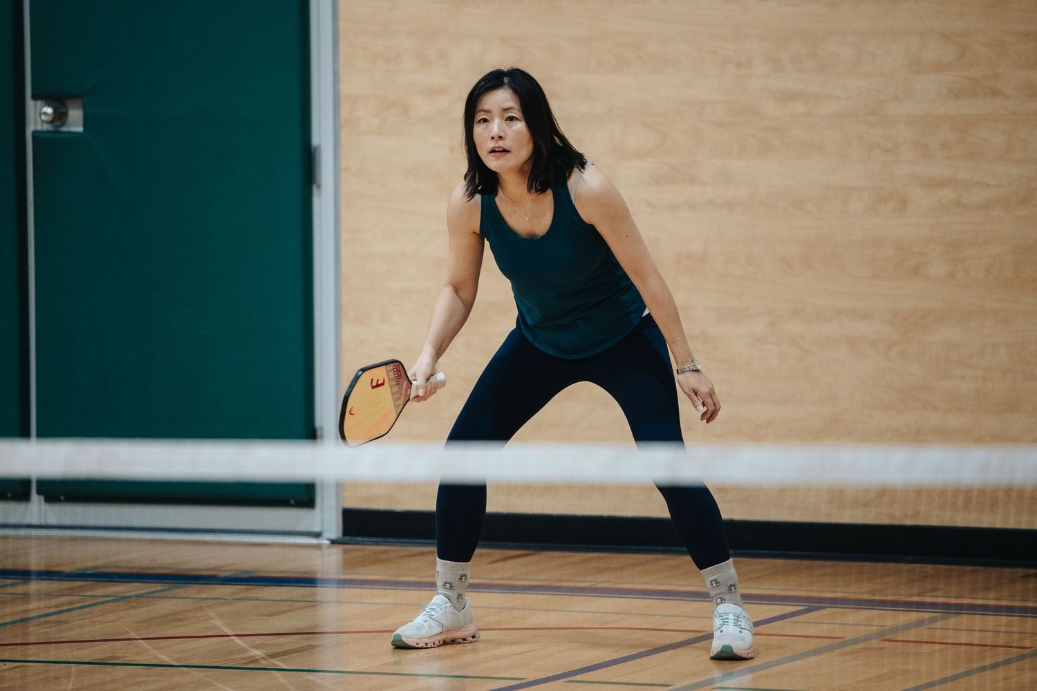 Person in athletic wear demonstrating fitness moves in a gym studio.