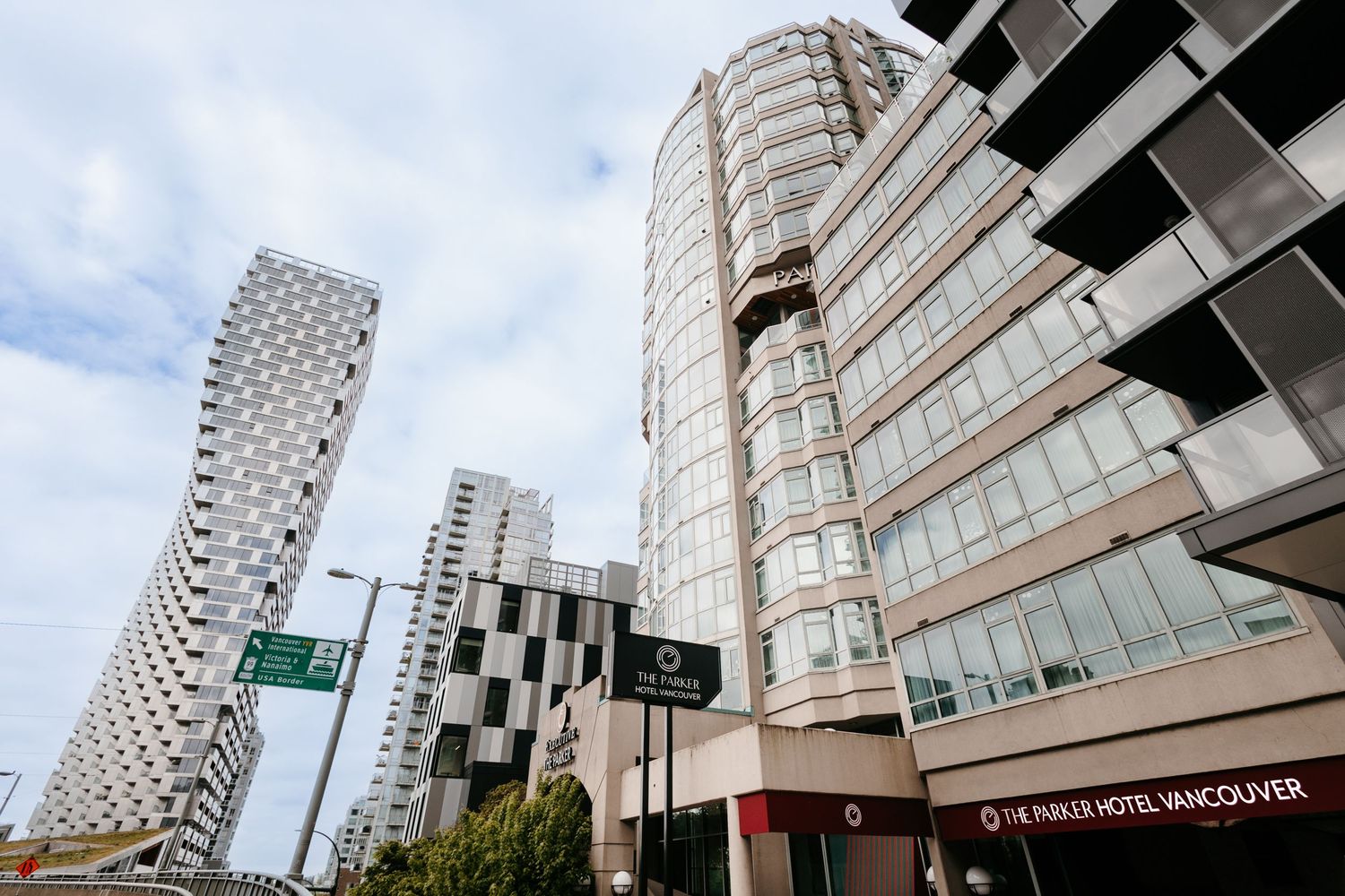 Exterior view of high-rise residential towers against blue sky in urban setting.