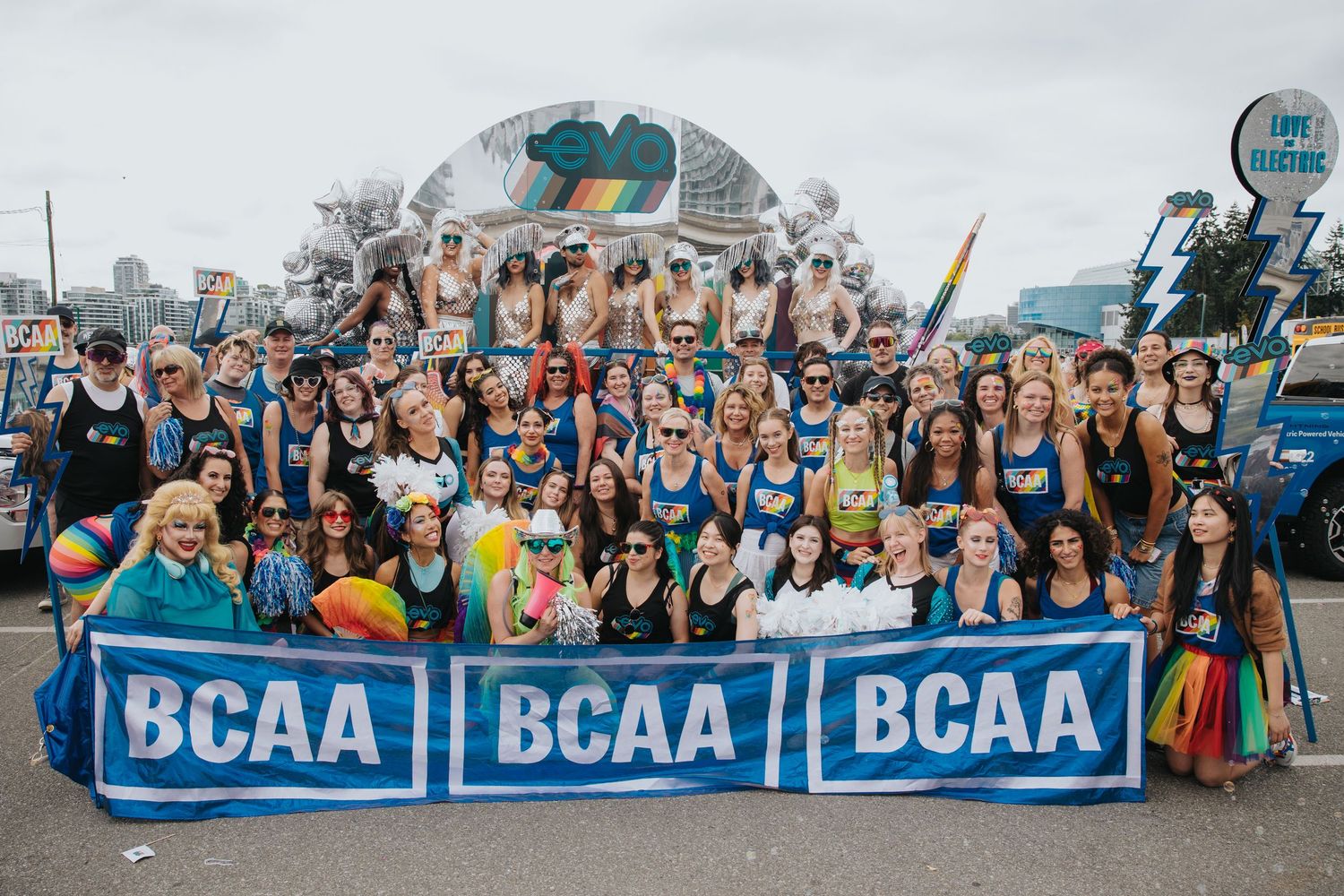 Large group wearing matching blue uniforms posing with BCAA banners.