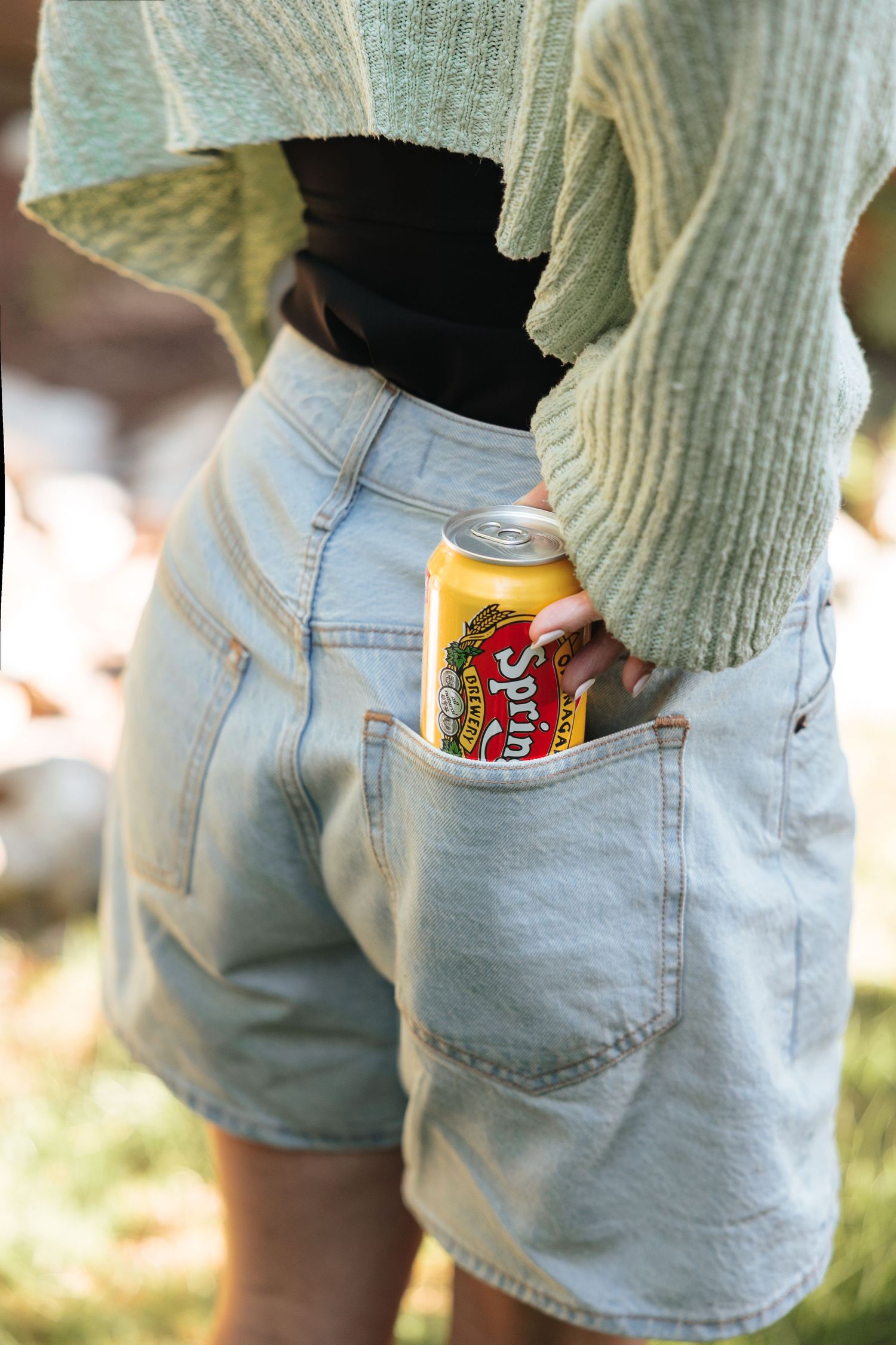 Spring Valley soda can tucked into back pocket of light wash denim shorts.