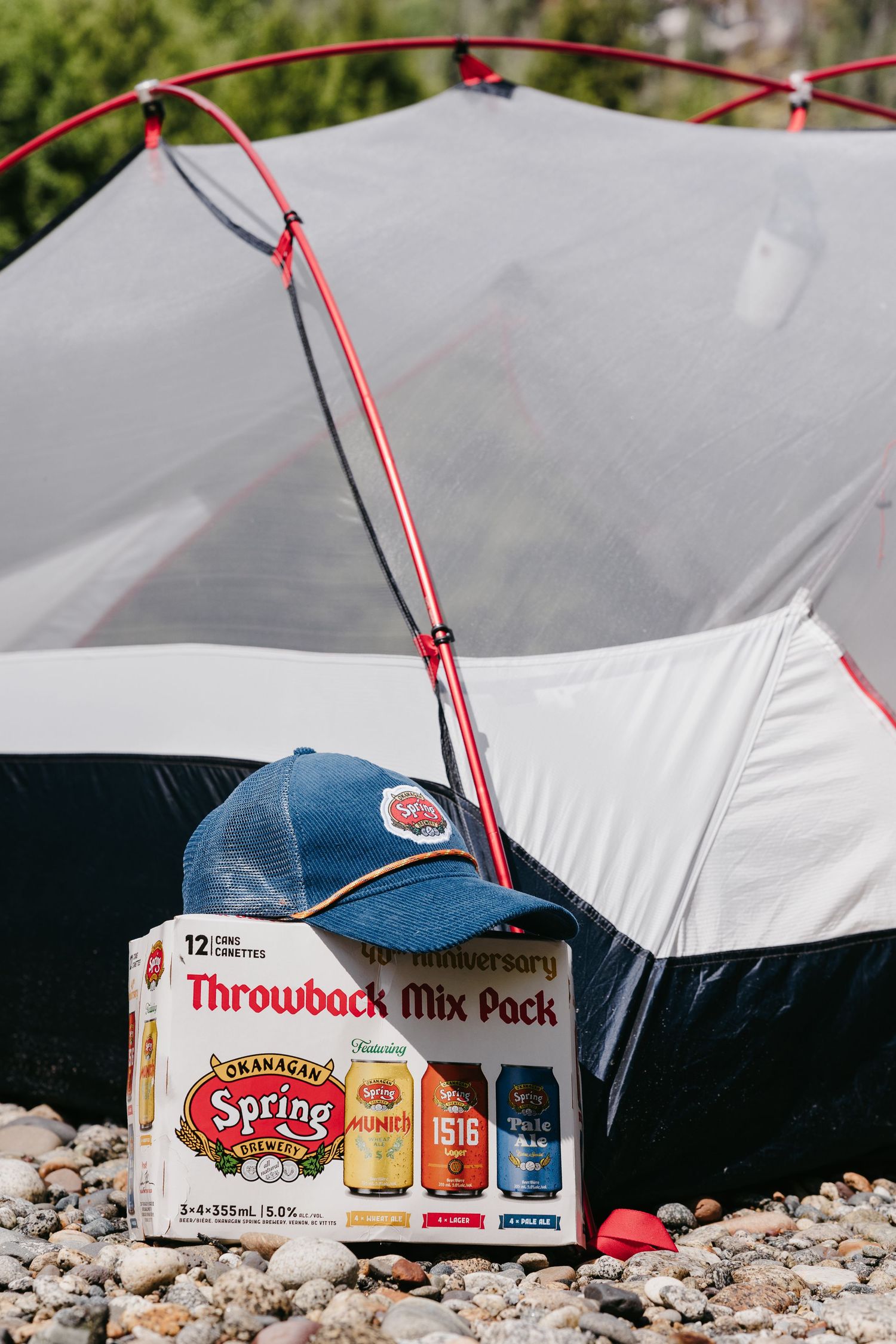 White camping tent with Spring Valley soda boxes visible near the entrance.