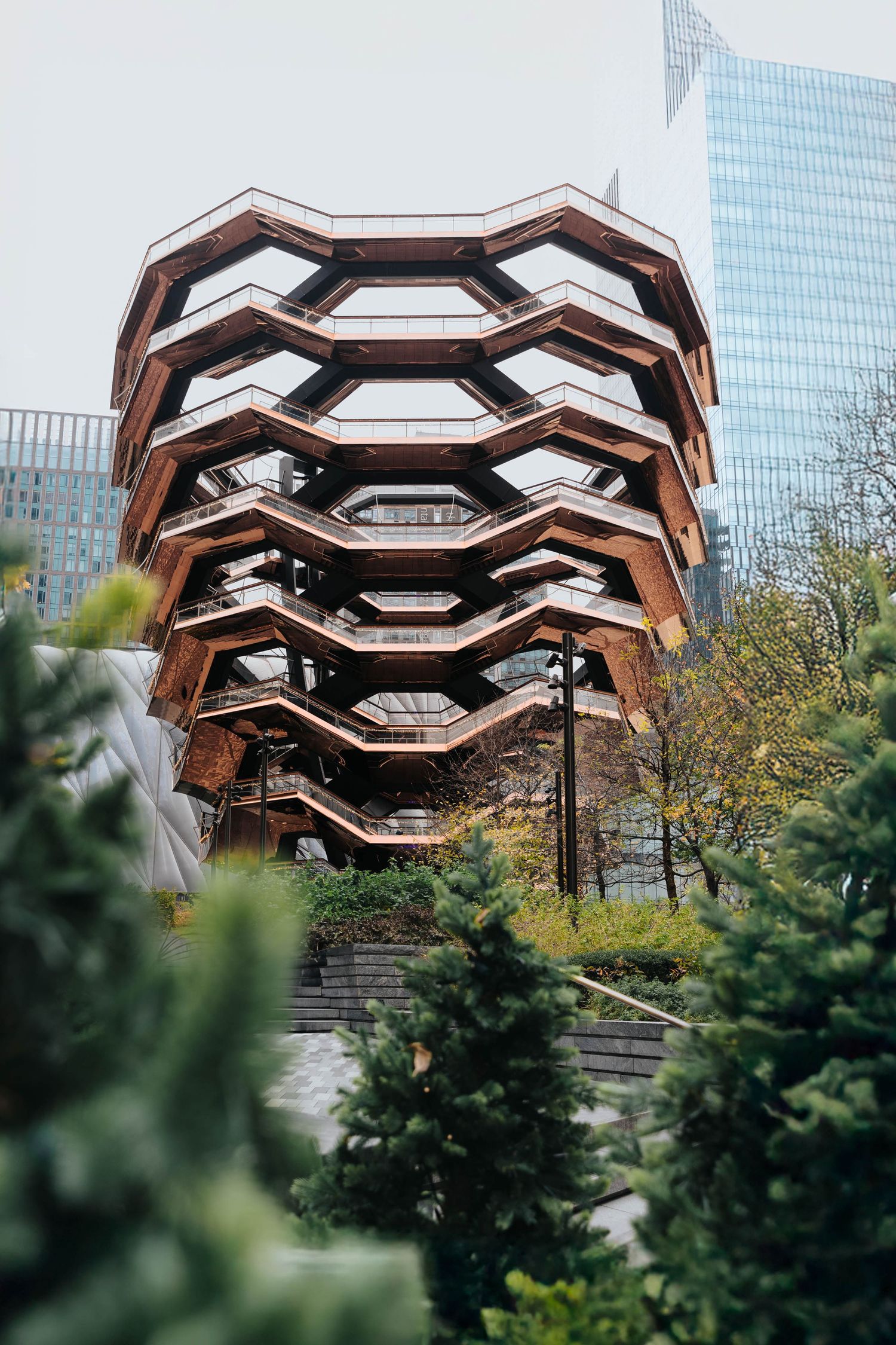 Modern honeycomb-shaped architectural structure with copper-colored metal panels.
