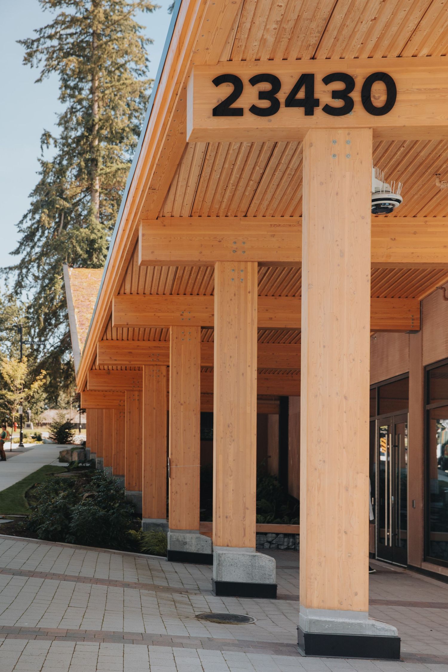 Architectural detail of wooden columns and beams on a modern building entrance.