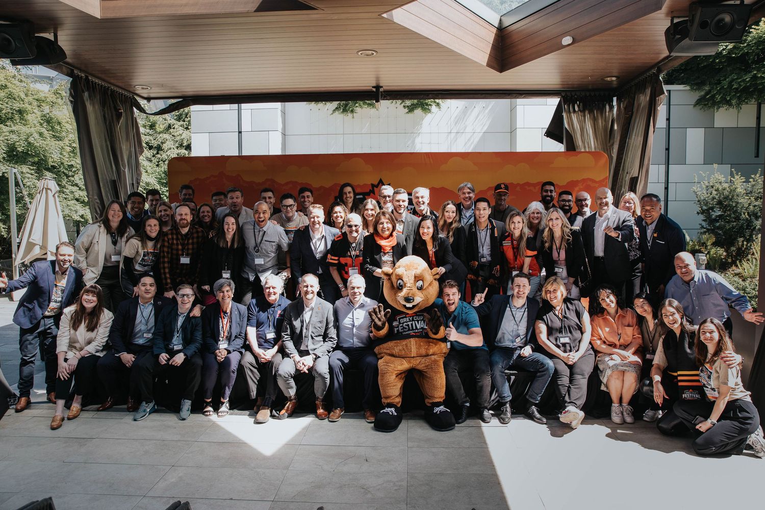 Group photo of conference attendees sitting together outside a building.