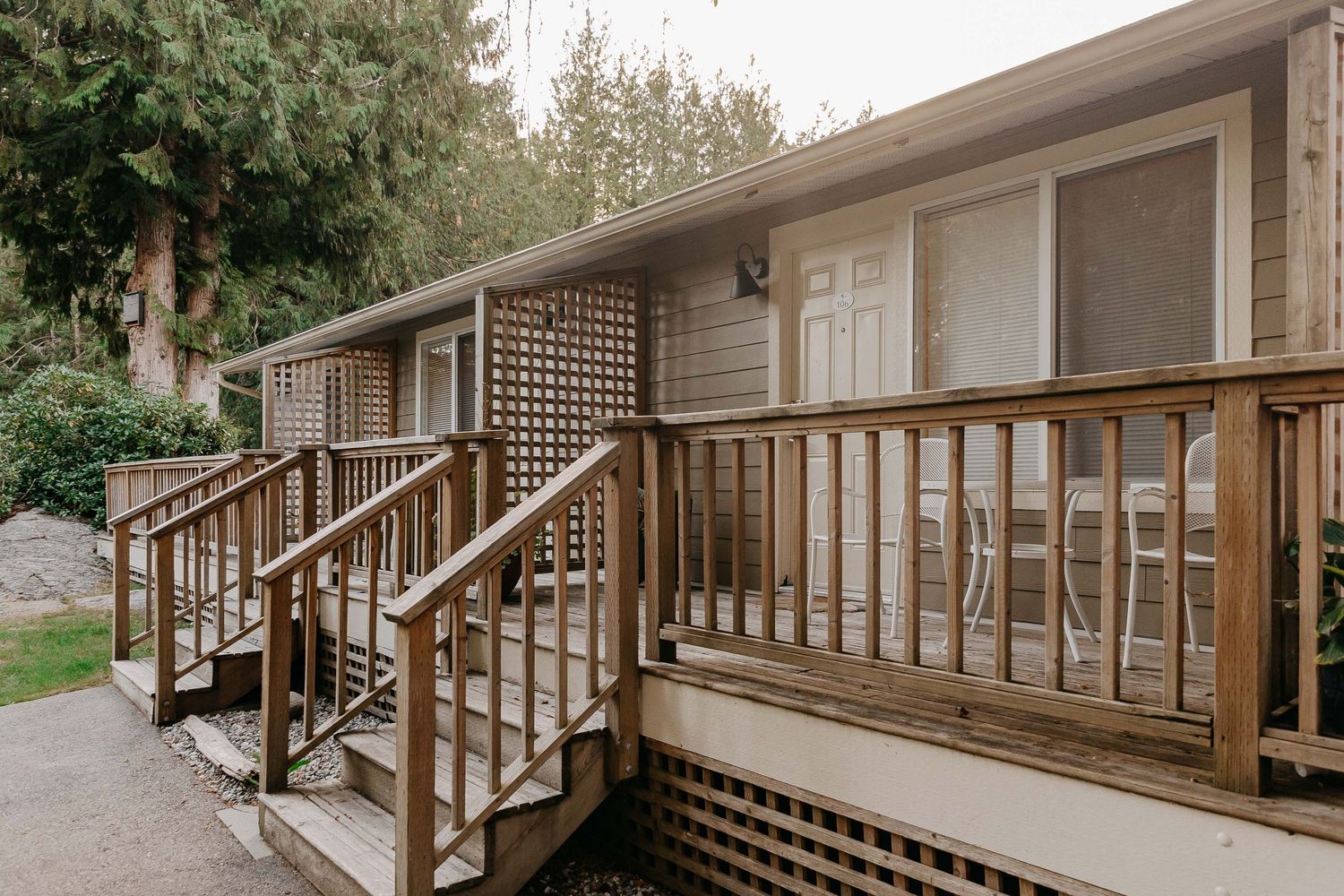 Wooden deck with stairs and lattice details on a rustic cabin exterior.