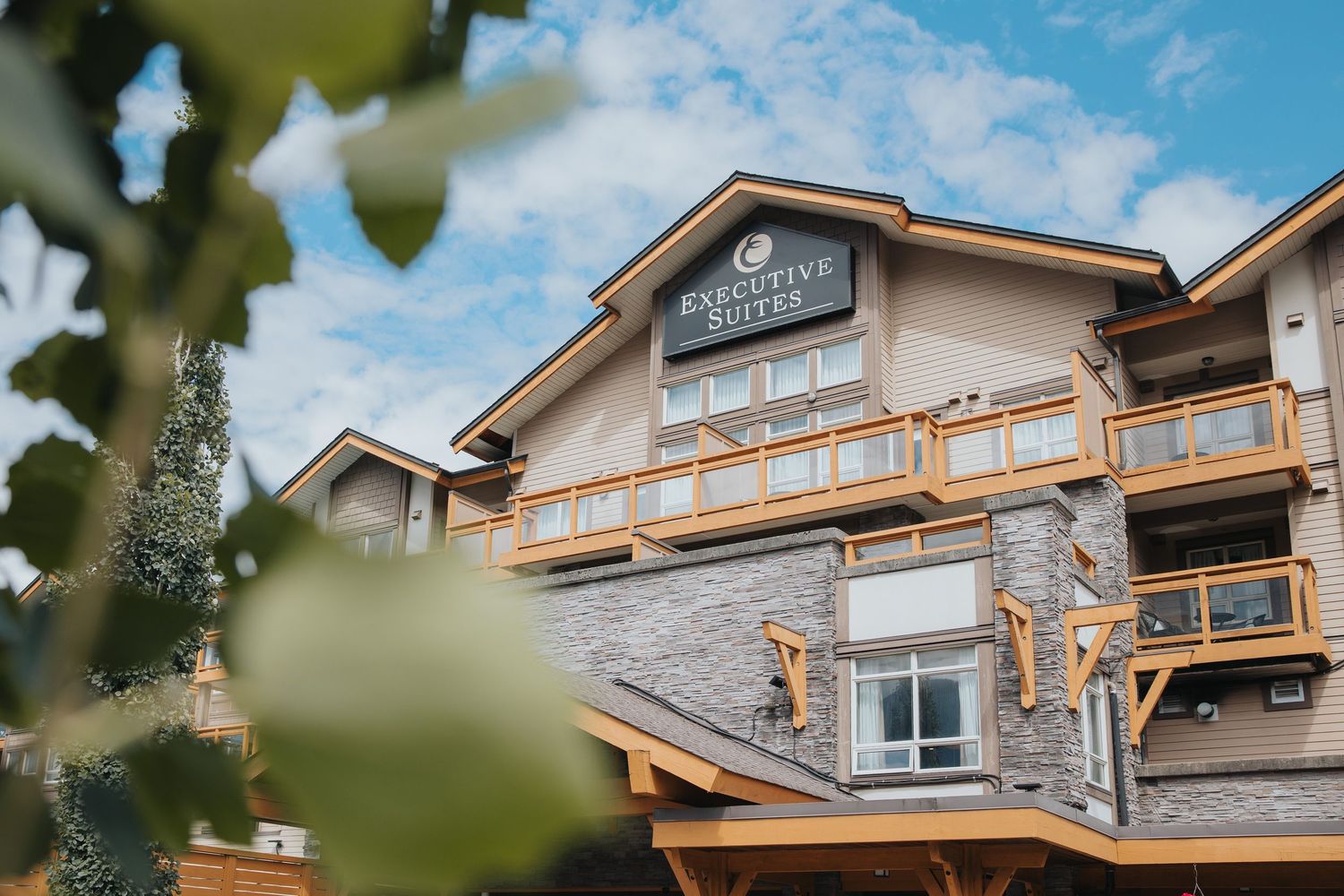 Luxury mountain lodge exterior with stone facade and wooden architectural elements.