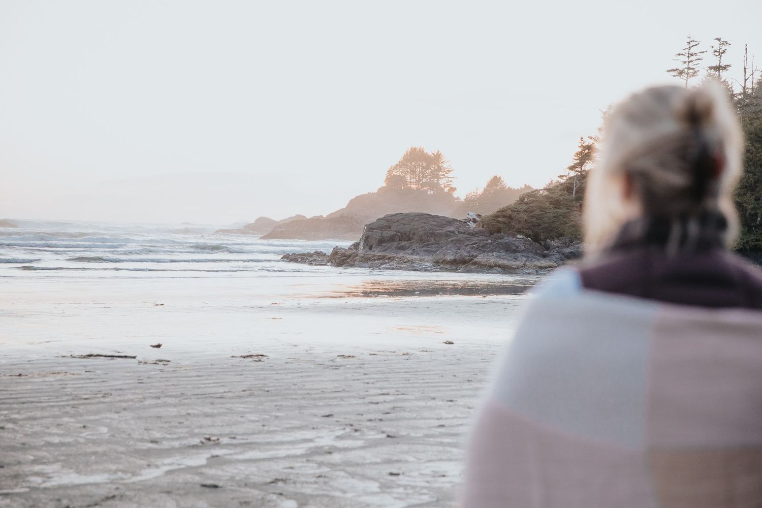 Scenic beach sunset view with palm trees and lounge chairs along the shoreline.
