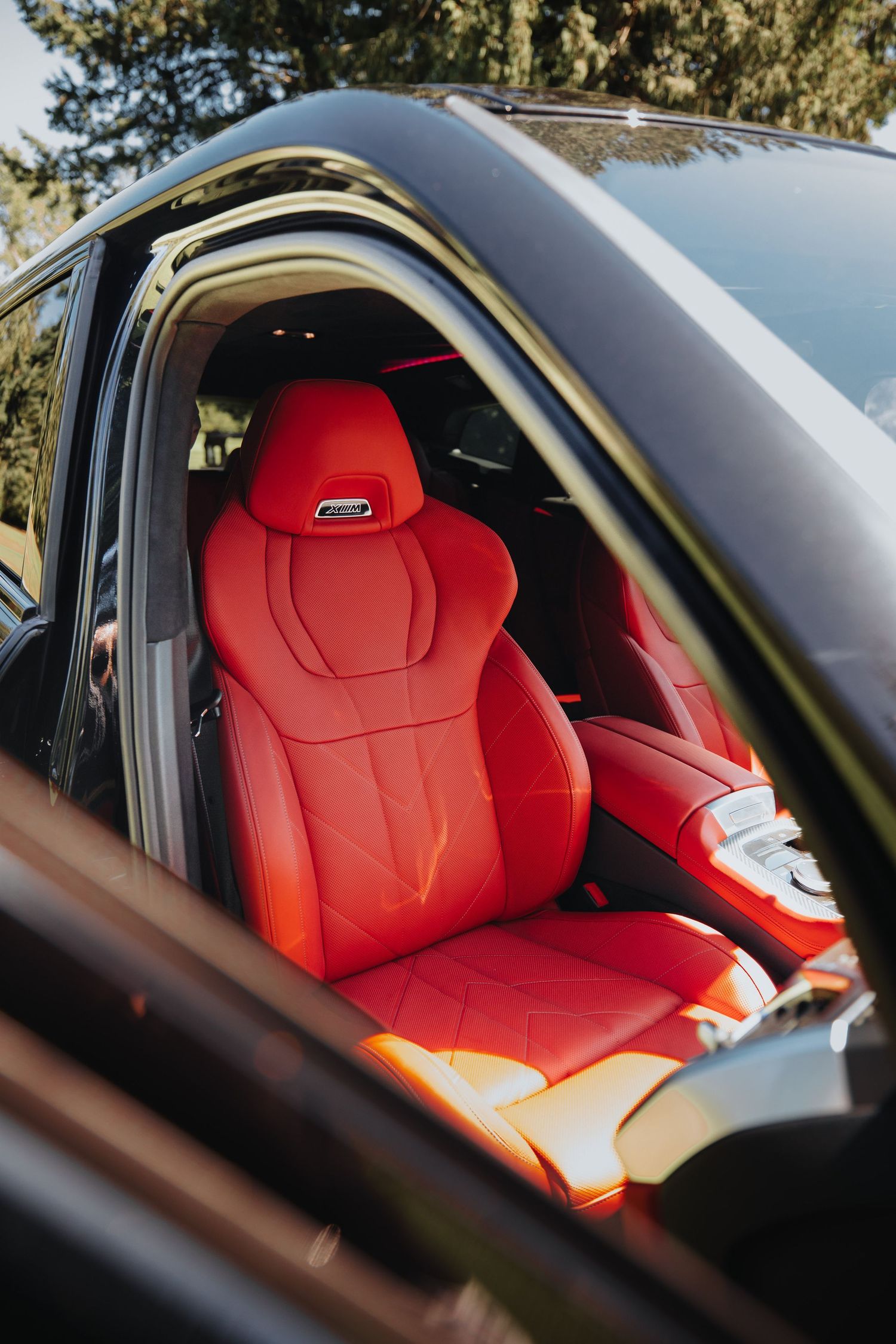 Luxury car interior featuring bright red leather sport seats.