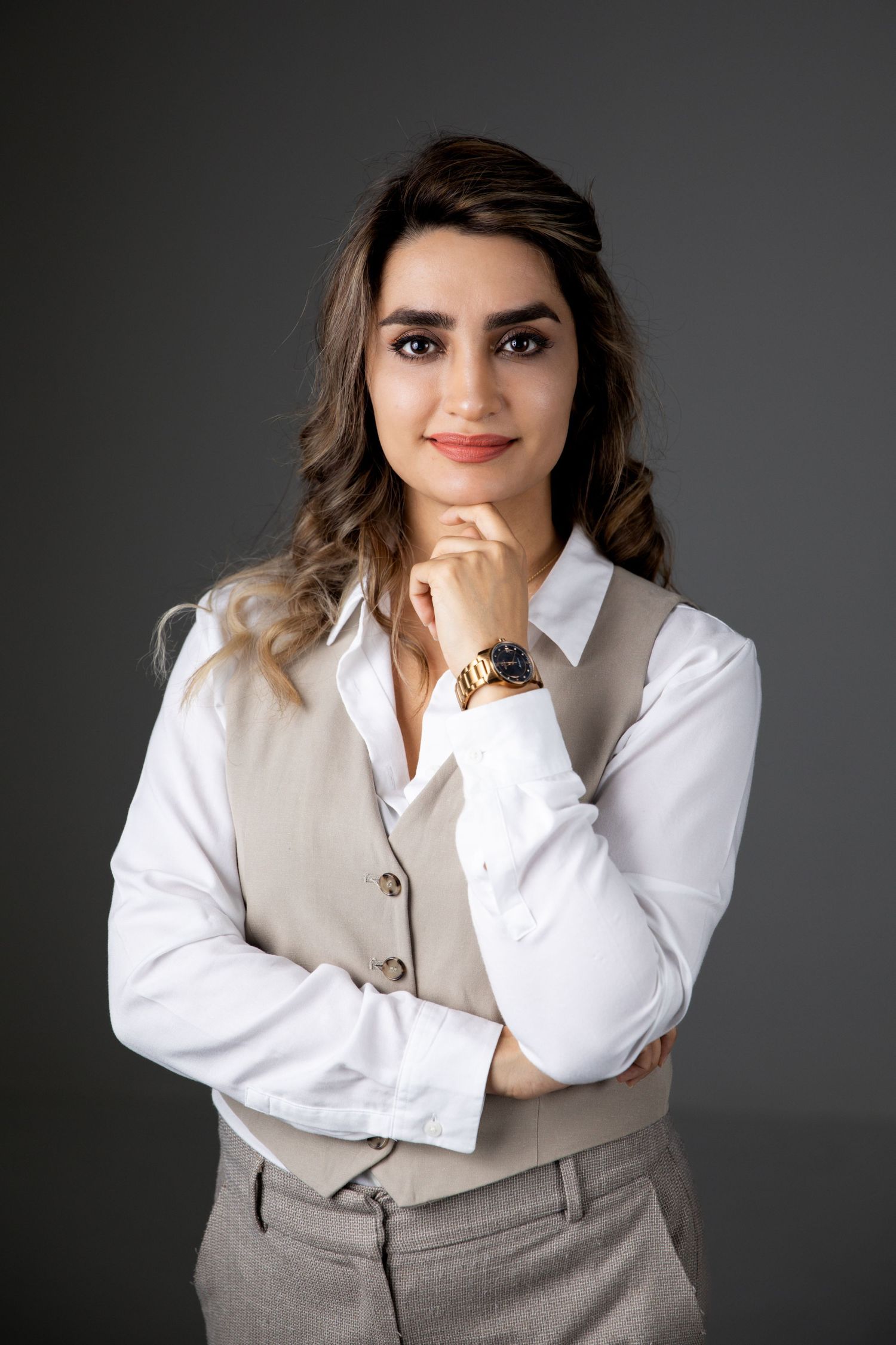 Professional studio portraits of a person in business attire posing against a dark gray background.
