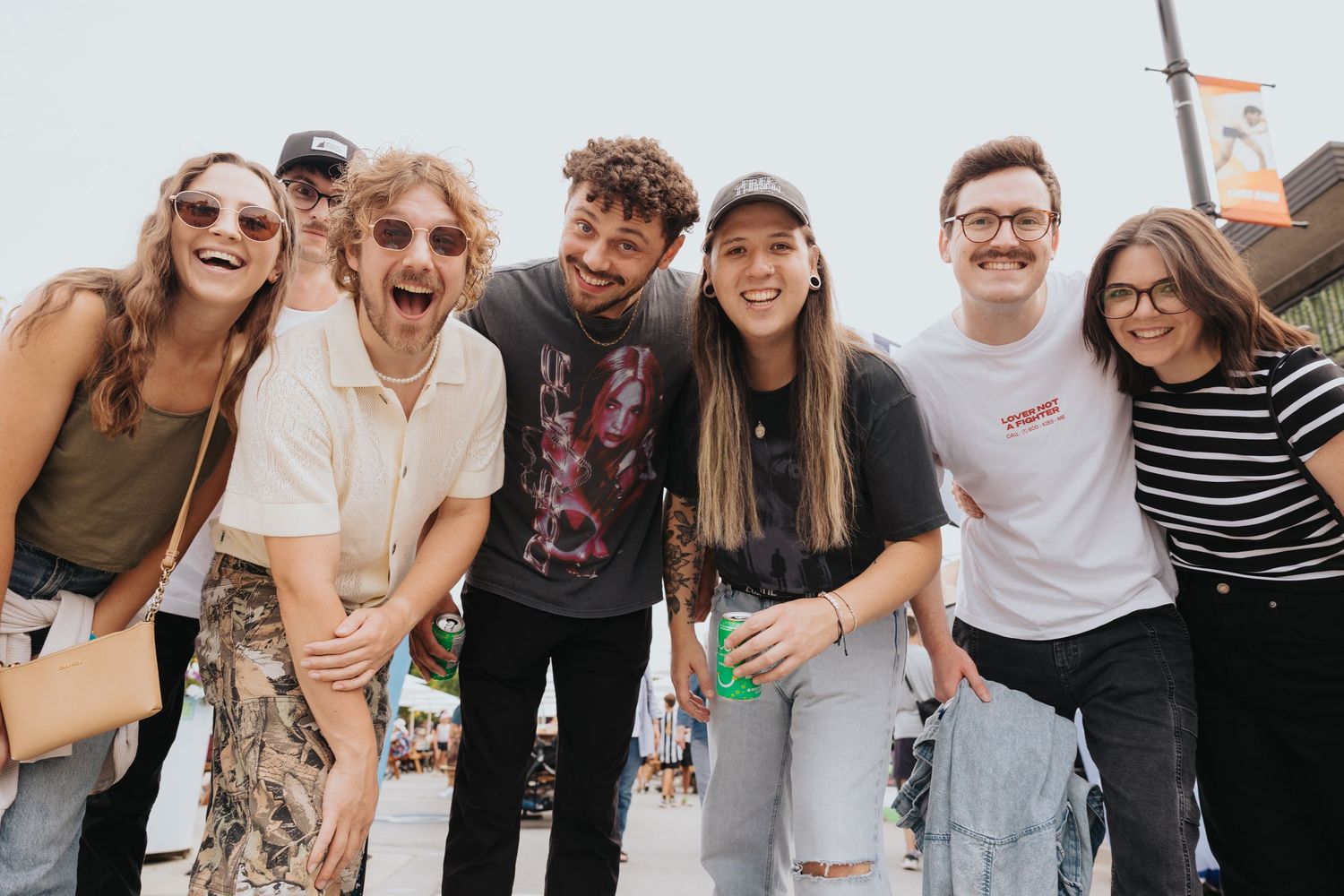 Happy group of friends posing together at an outdoor community celebration.