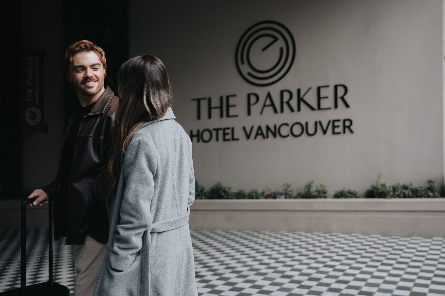 Modern hotel lobby entrance with The Parker Hotel Vancouver branding on wall.