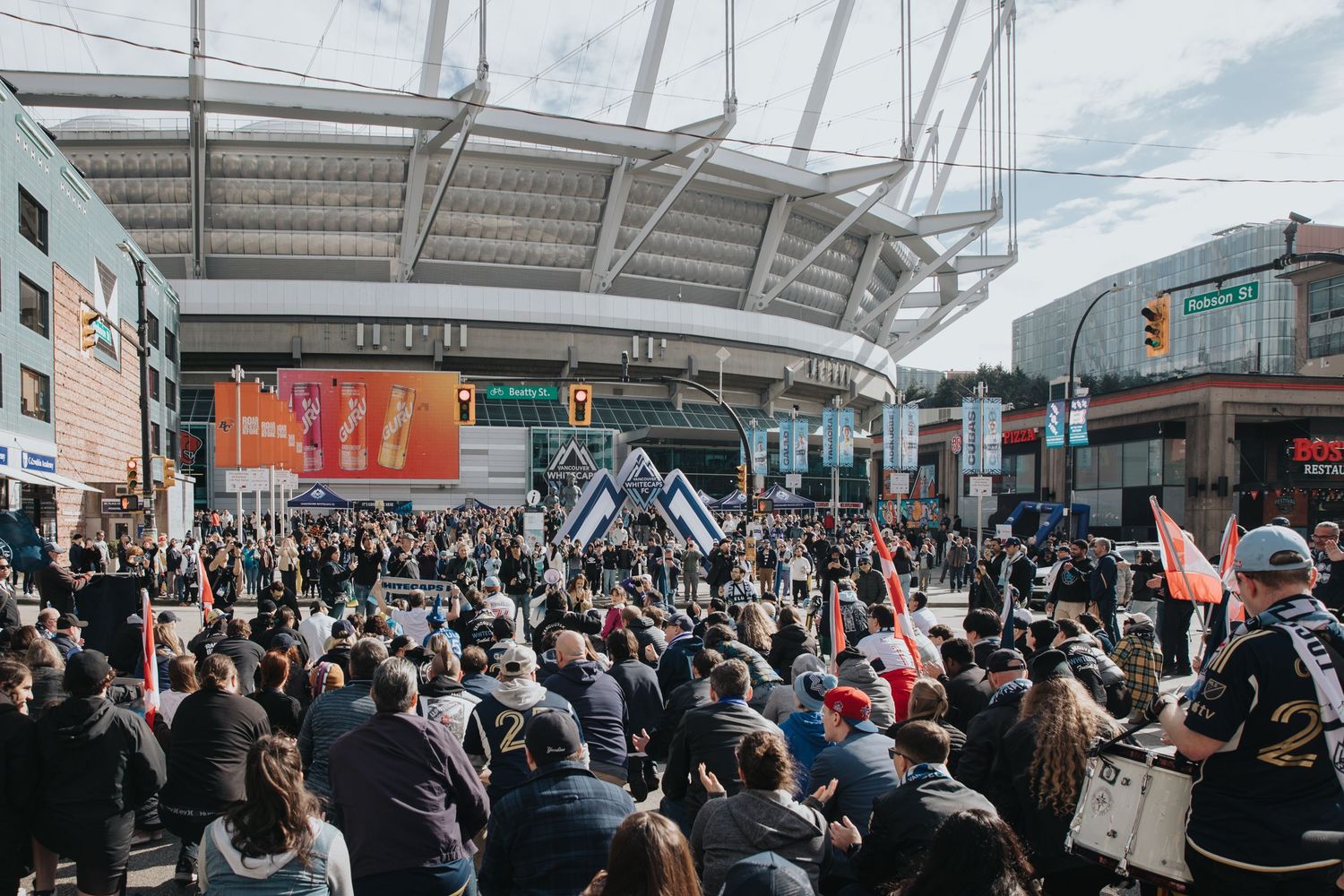 Large crowd gathered outside BC Place stadium for a Vancouver Whitecaps soccer match.