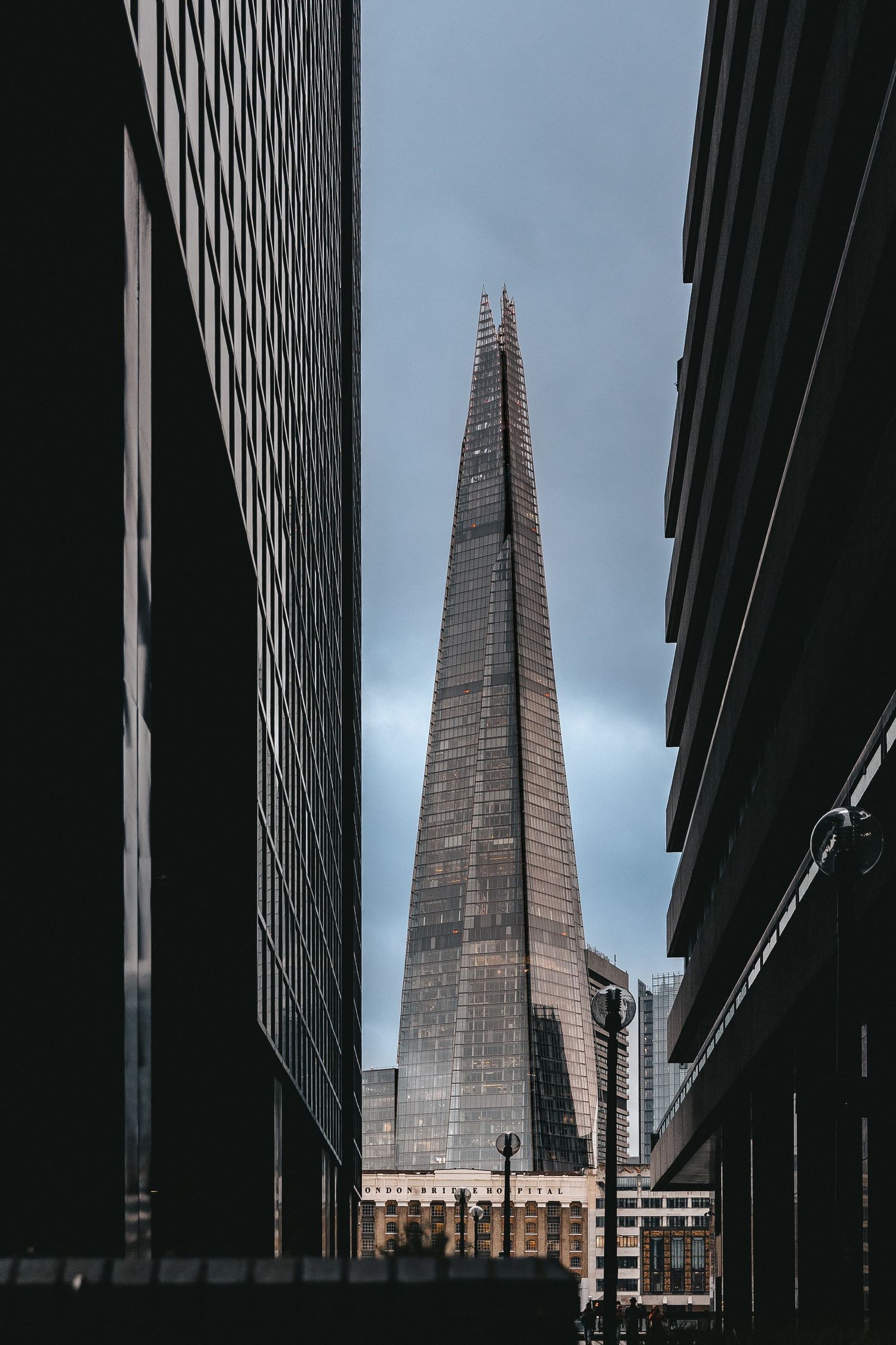 The Shard skyscraper in London viewed through urban canyon of office buildings.