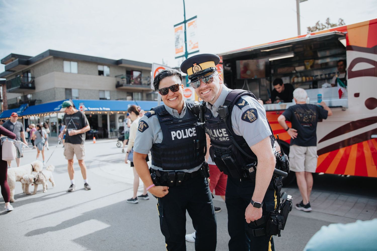 Police officers patrol and interact with visitors at an outdoor festival or event.