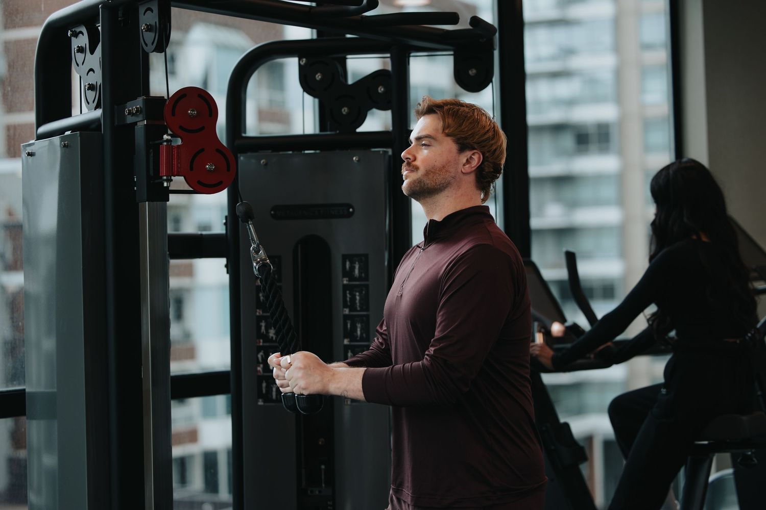 Hotel fitness center with modern exercise equipment and city views.