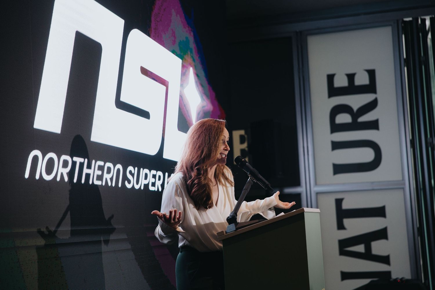 Modern conference space with illuminated signage and presentation screens.