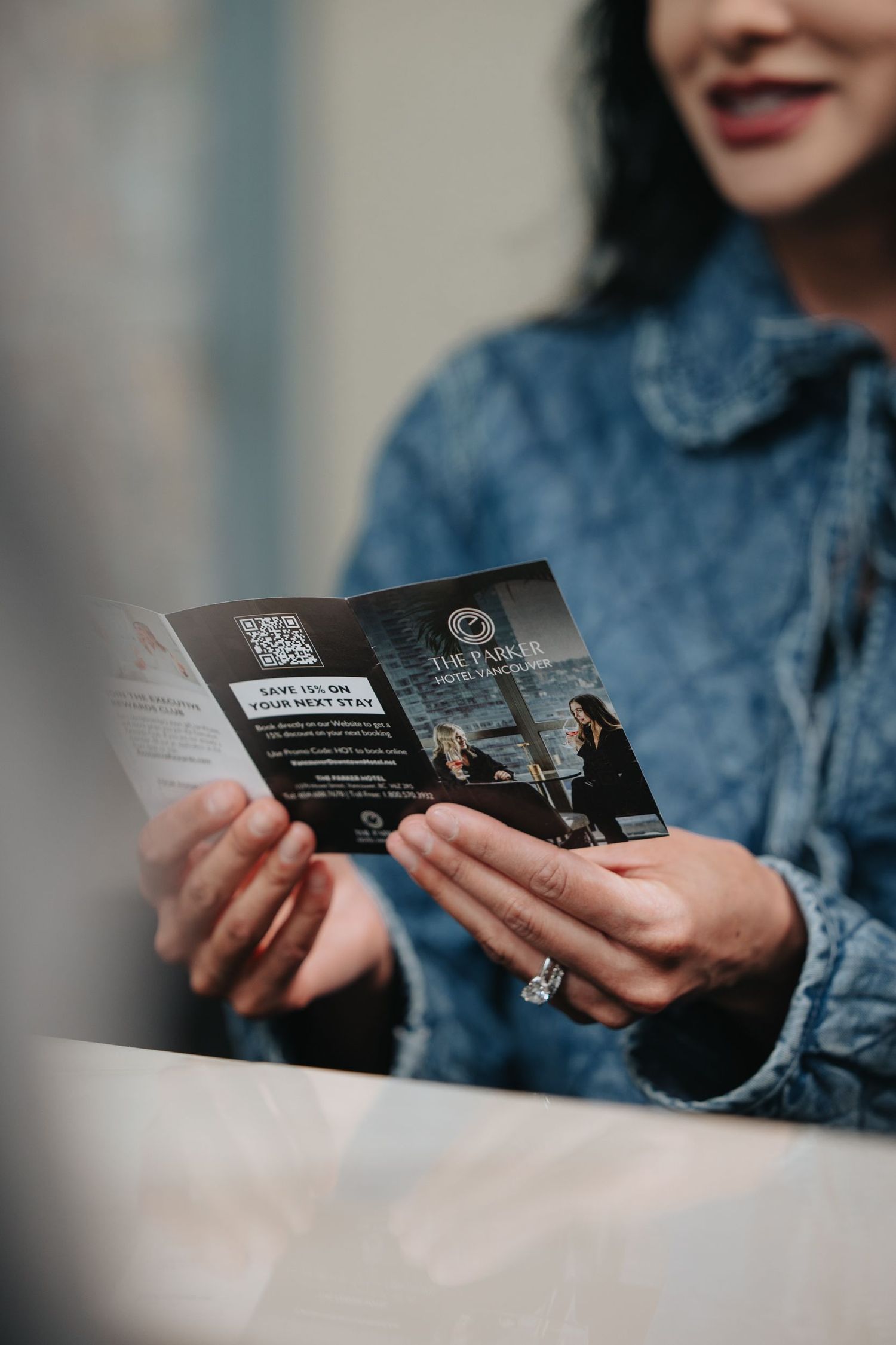 Hands holding and examining business cards or brochures in dim lighting.