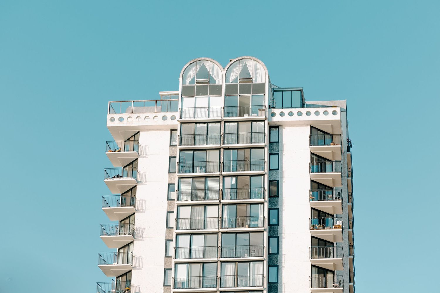 Modern residential tower with glass balconies and contemporary architectural design.