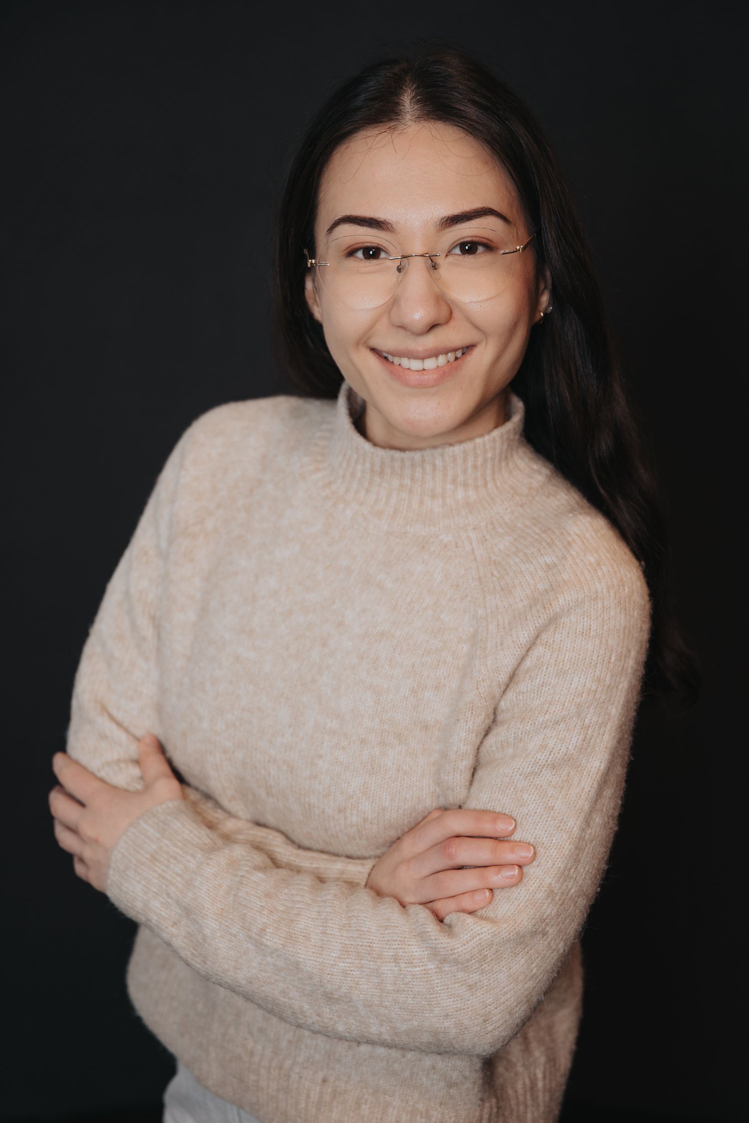 Studio portraits showing joyful expressions in cream sweater against dark background.