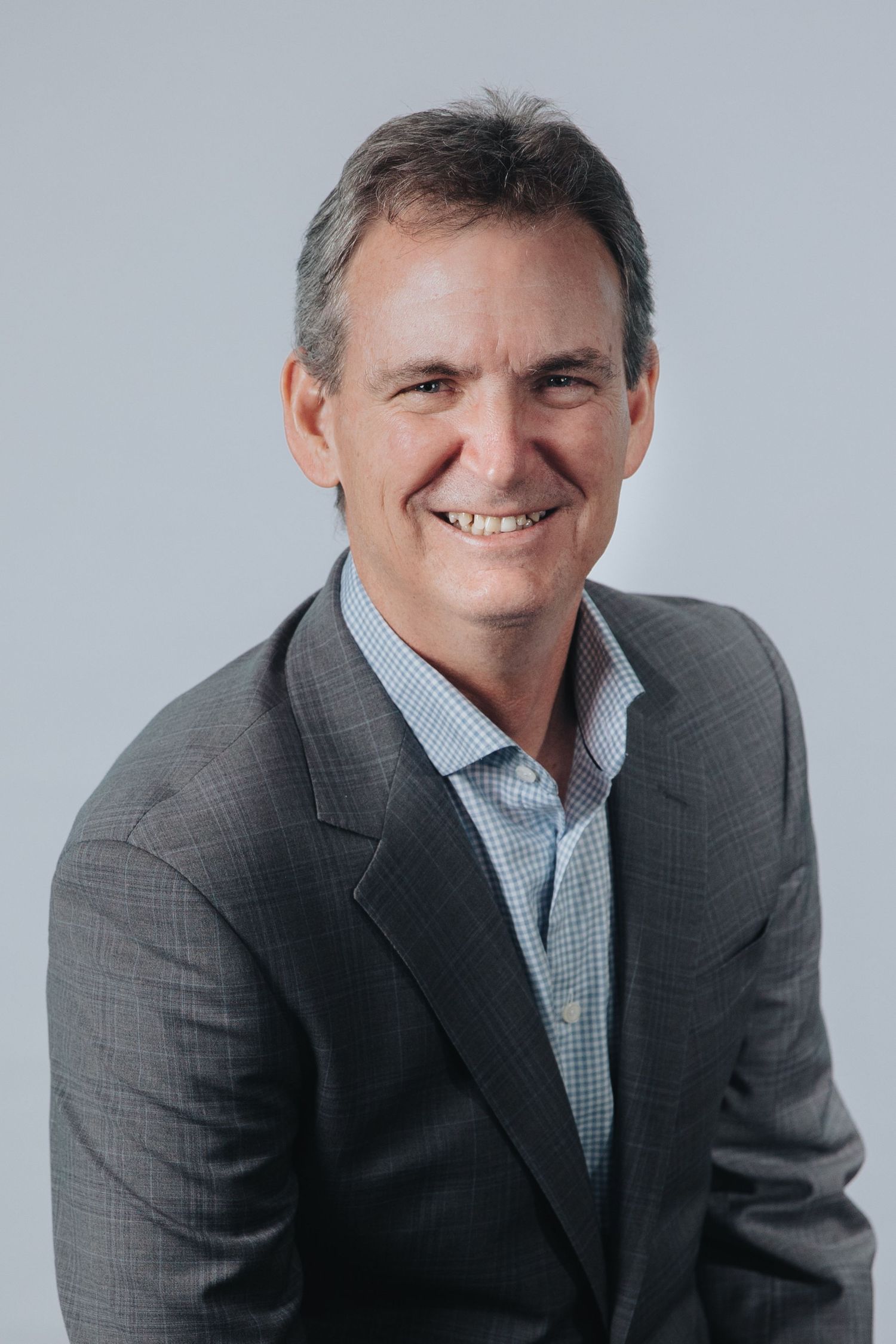 Business portrait sequence showing person in suit jacket and checked shirt with warm expression.